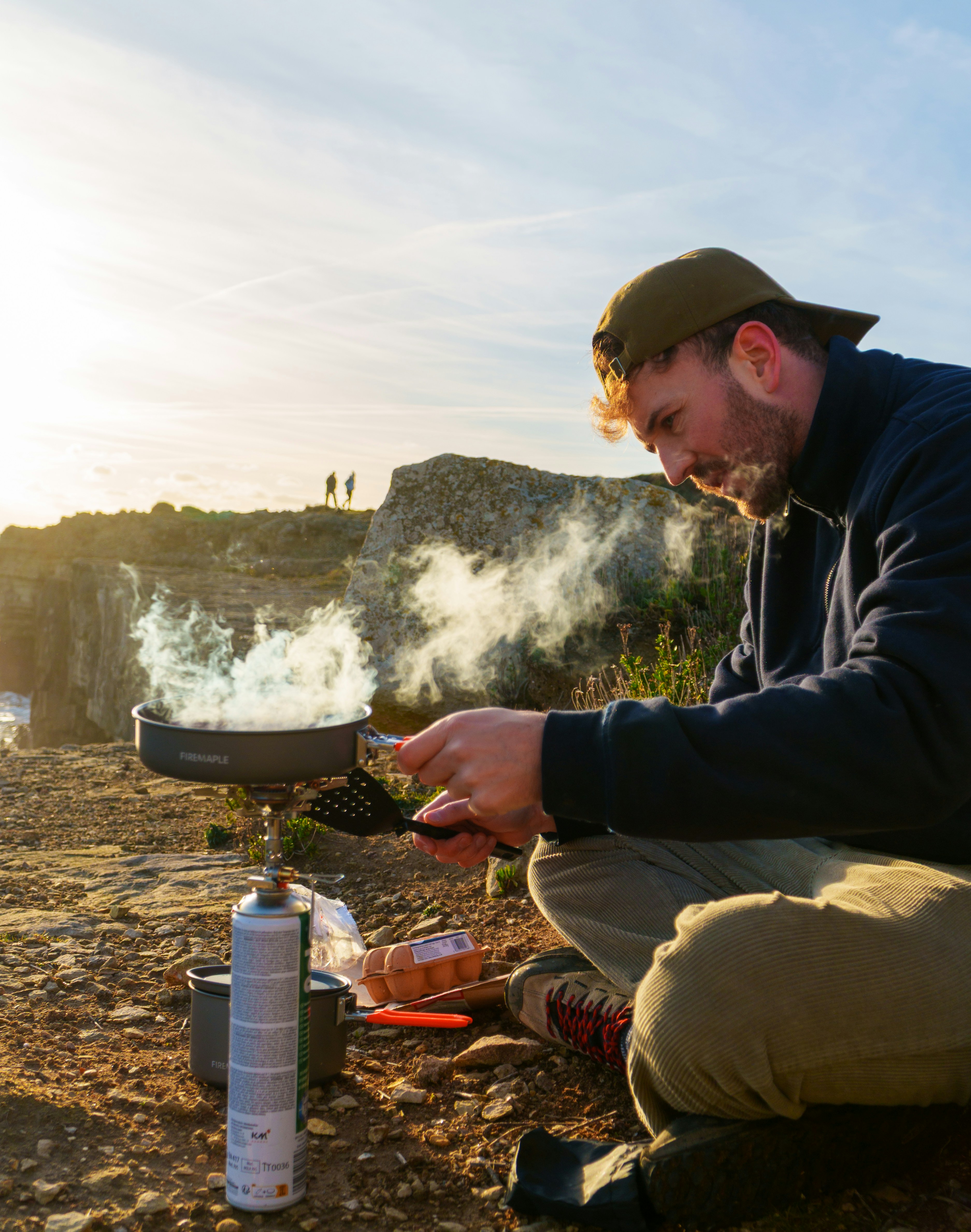 Man cooking outdoors with a camping stove