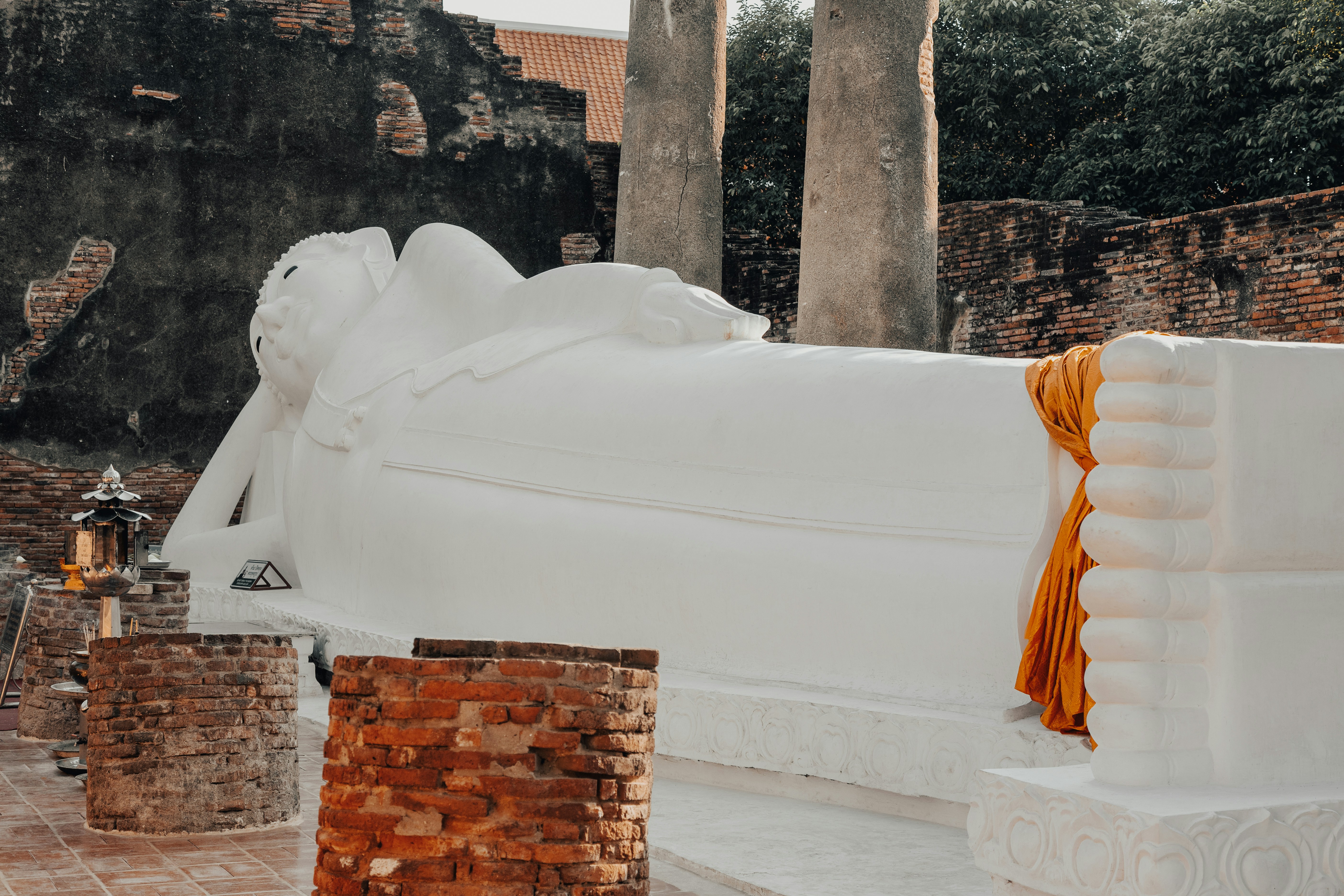 Reclining buddha statue with orange cloth draped.