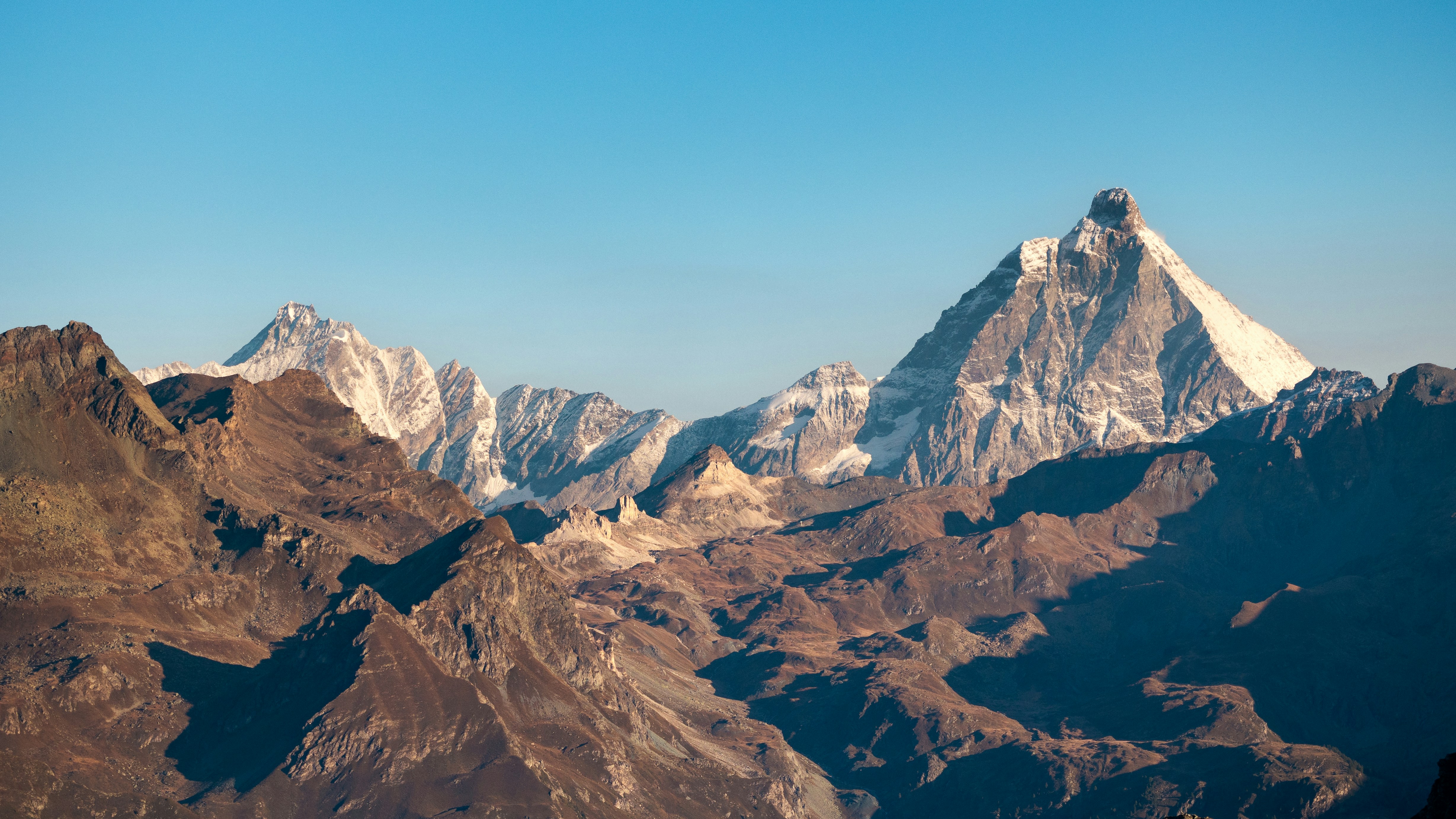 Majestic mountain range under a clear blue sky.