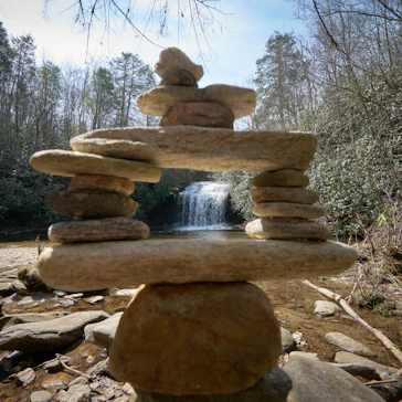 Stacked stones in front of a waterfall