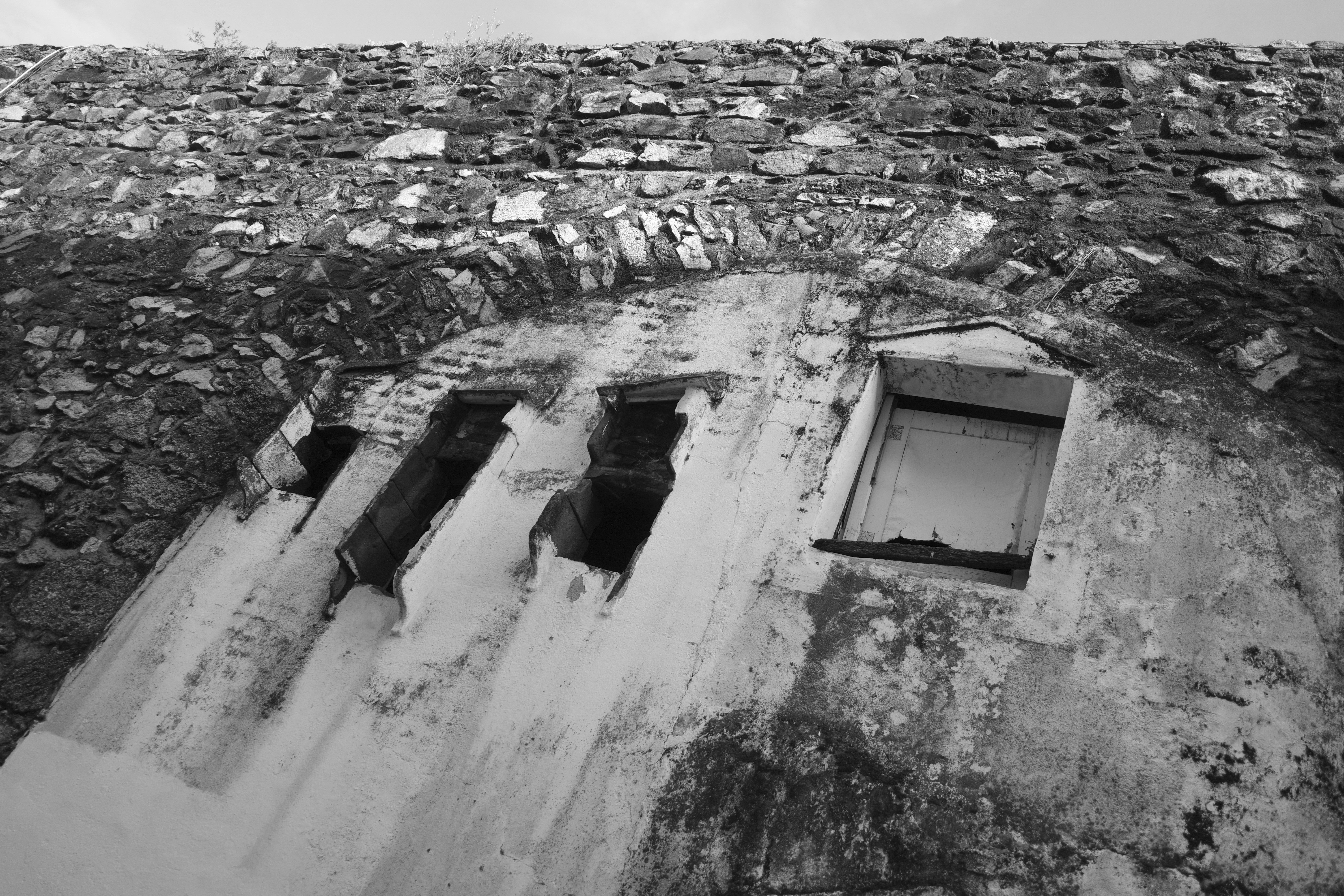 Close-up of an old stone wall with arched openings.