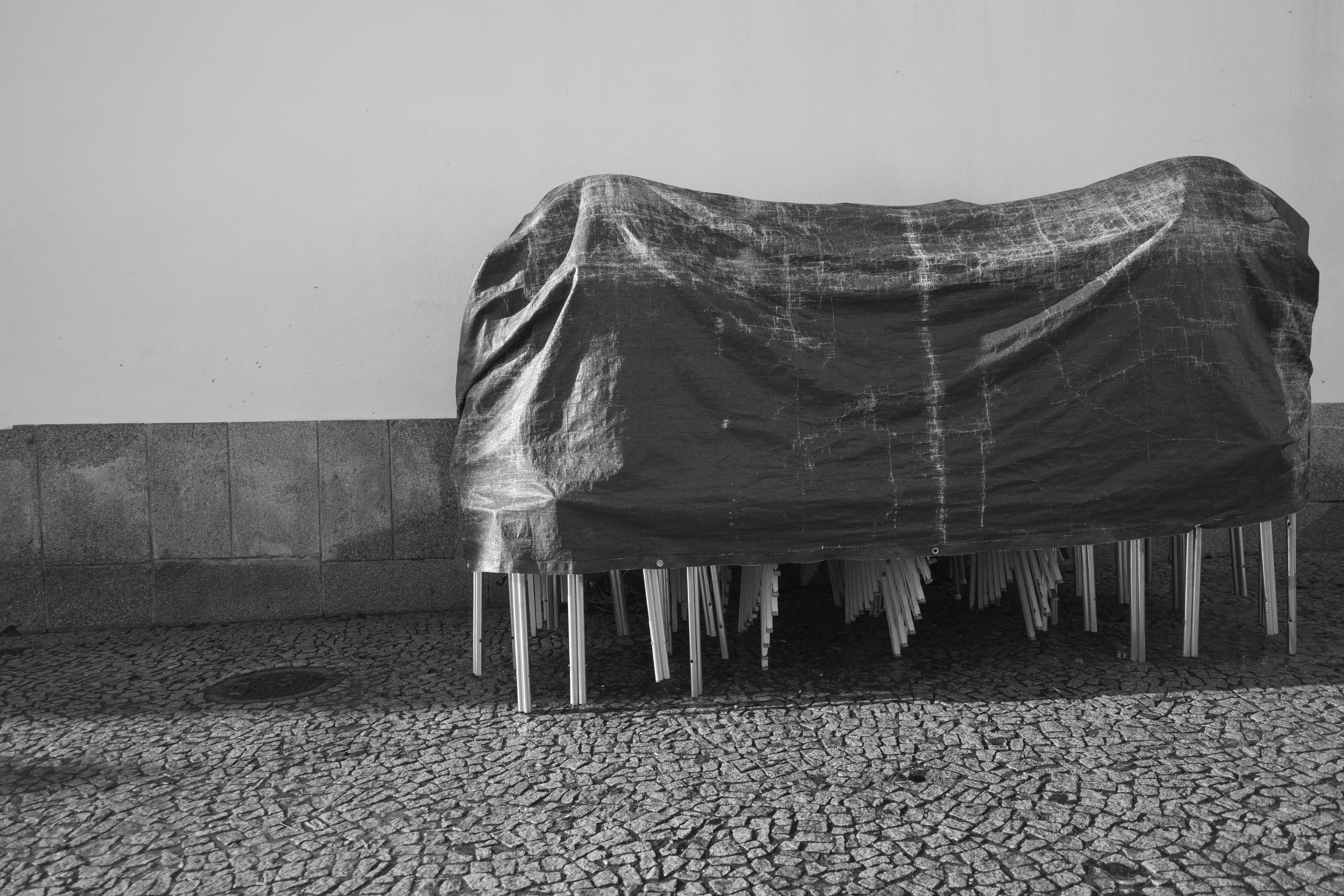 Furniture covered with plastic sheeting outdoors