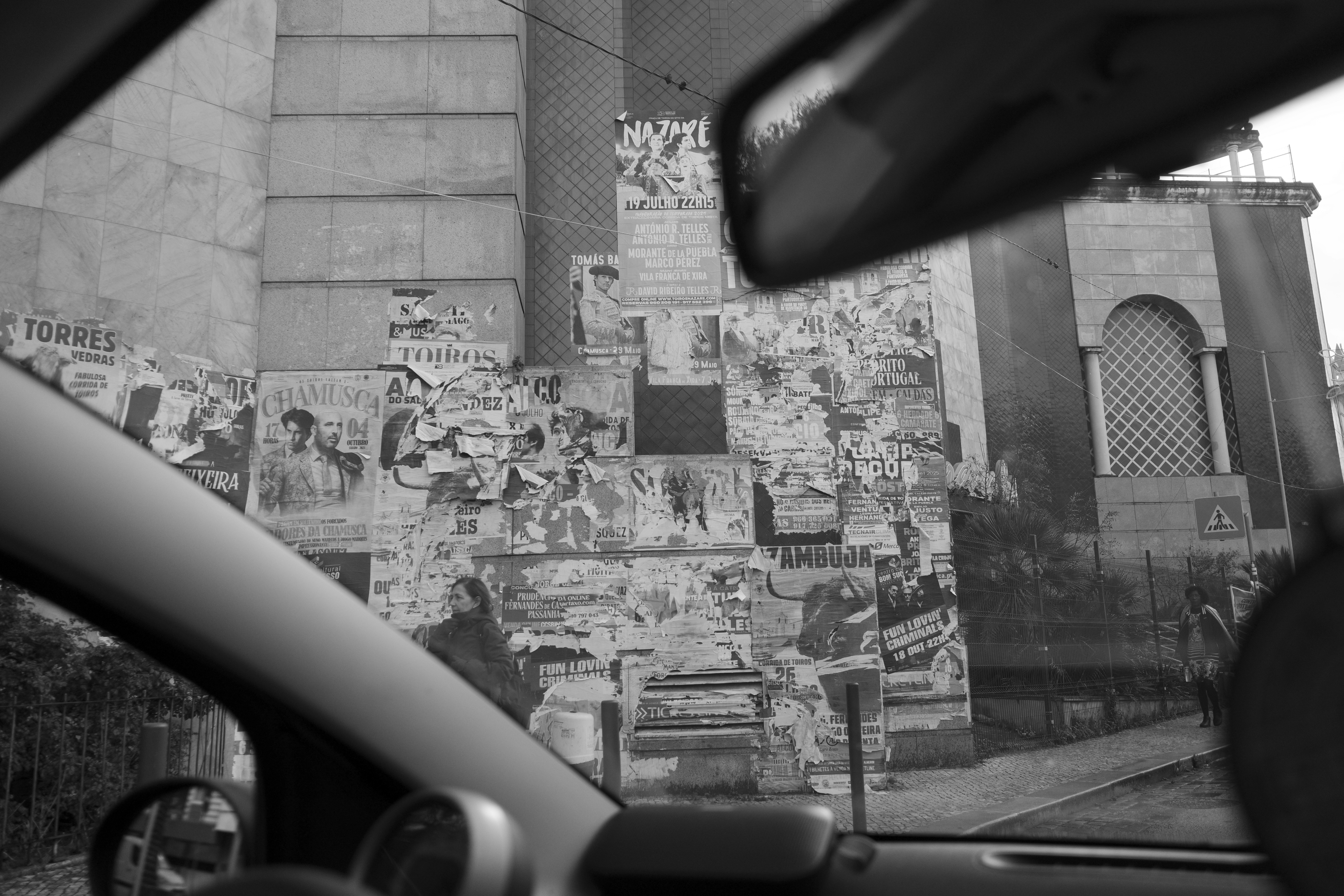 View from car of building covered in old posters