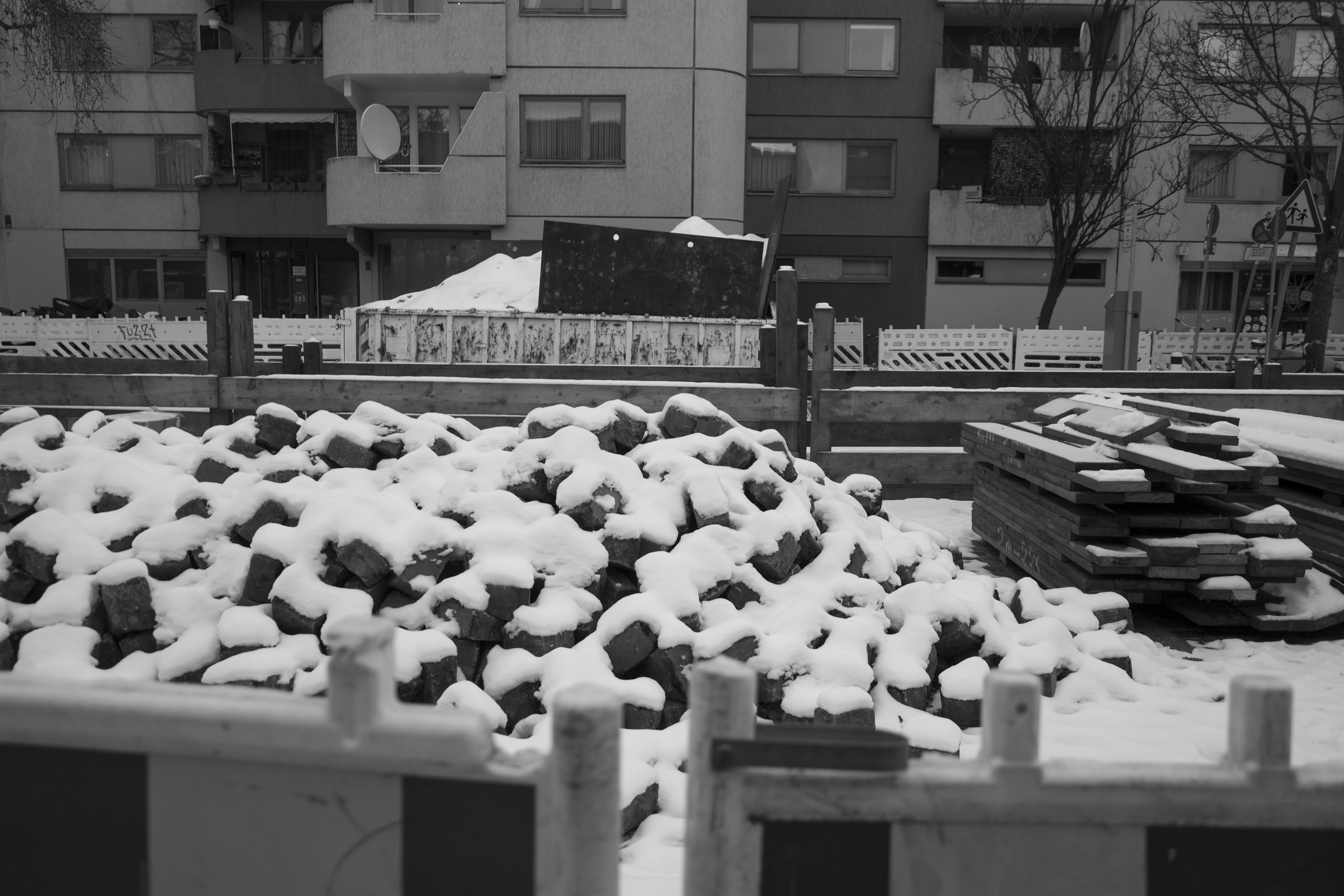 Pile of snow-covered bricks at construction site.