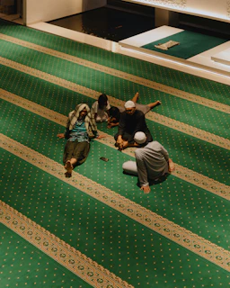 People resting on a green carpet with striped patterns.