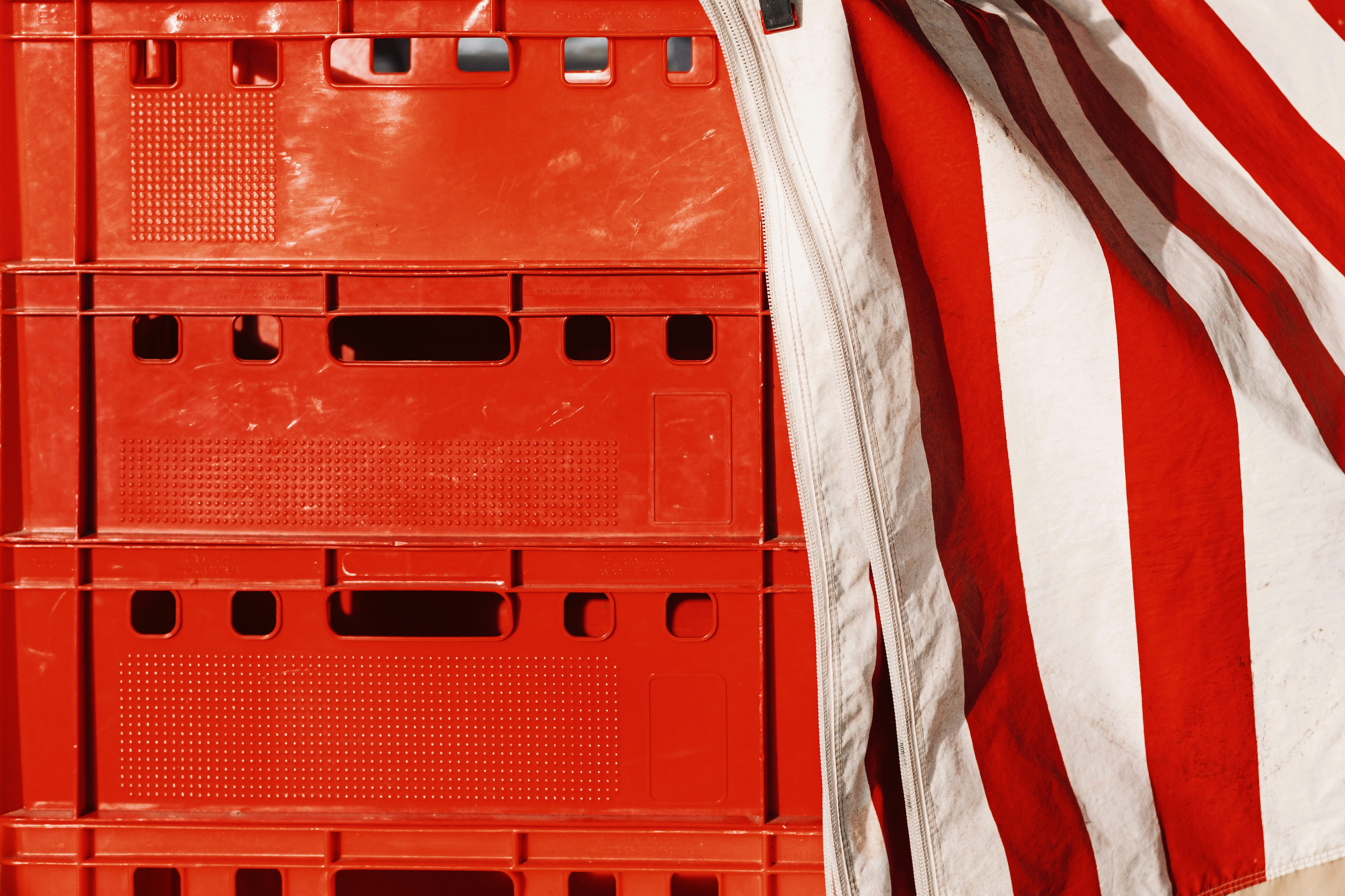 Stack of red crates with red and white striped fabric.