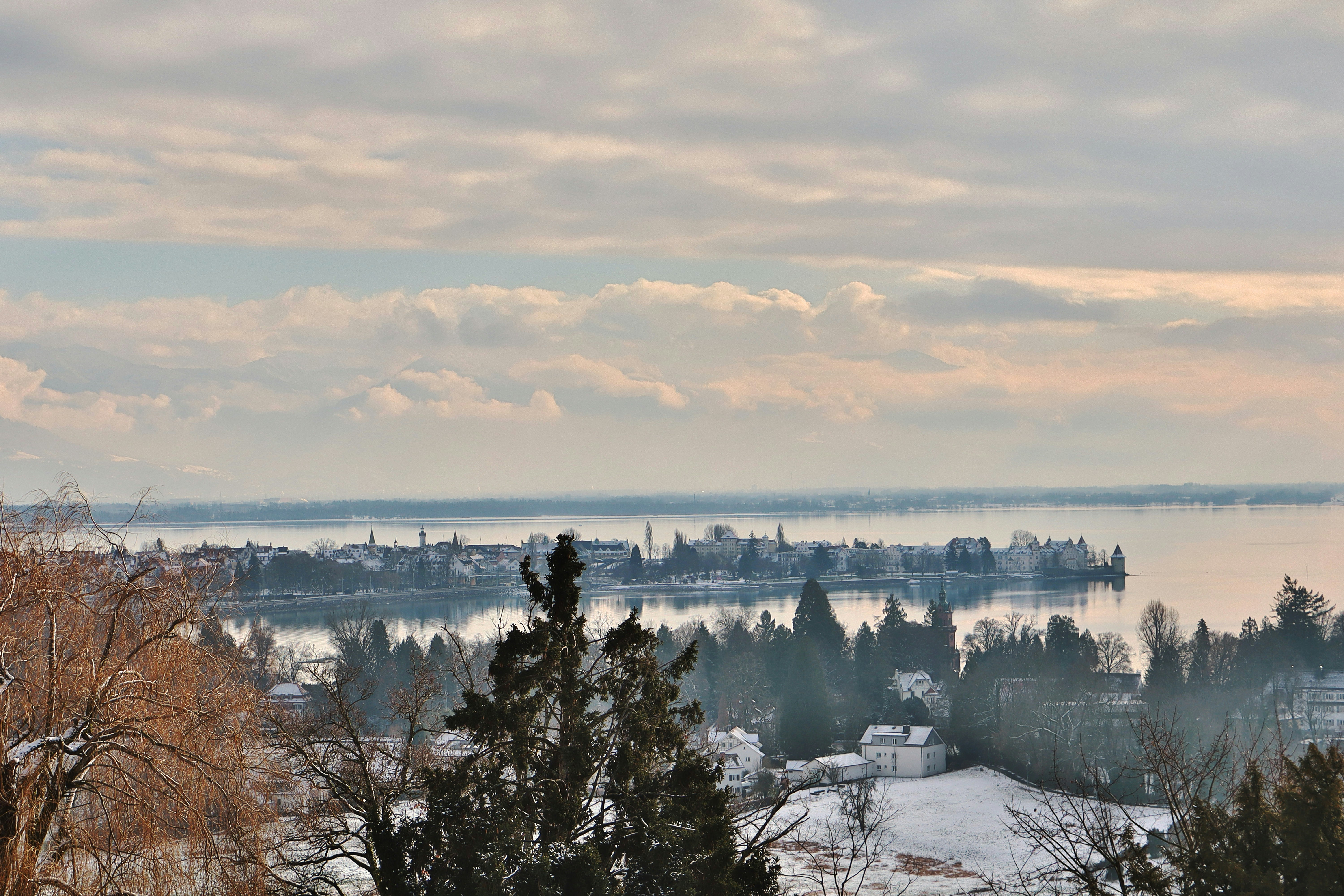 Winter landscape with a distant town across a lake.