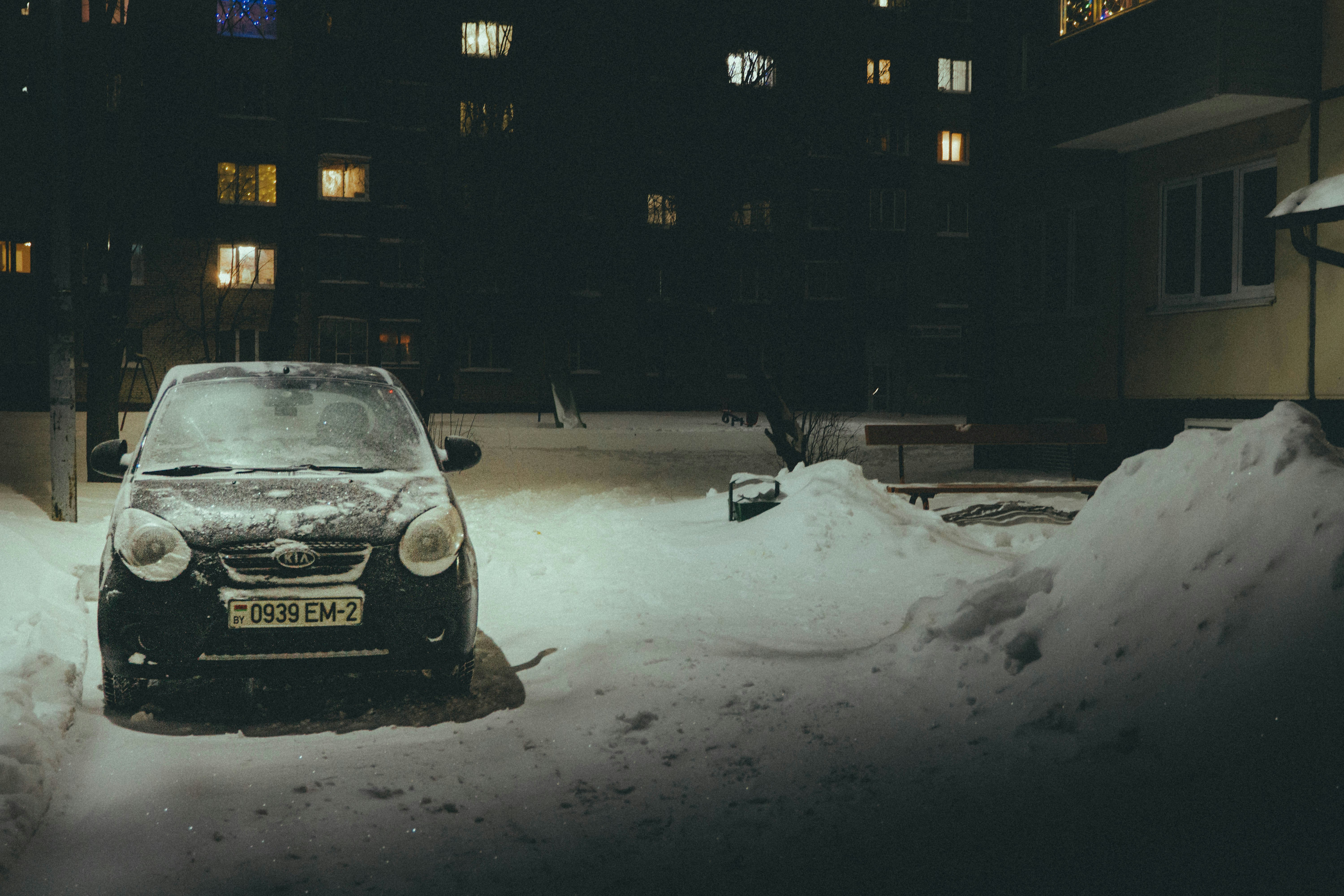 A car parked in the snow at night.