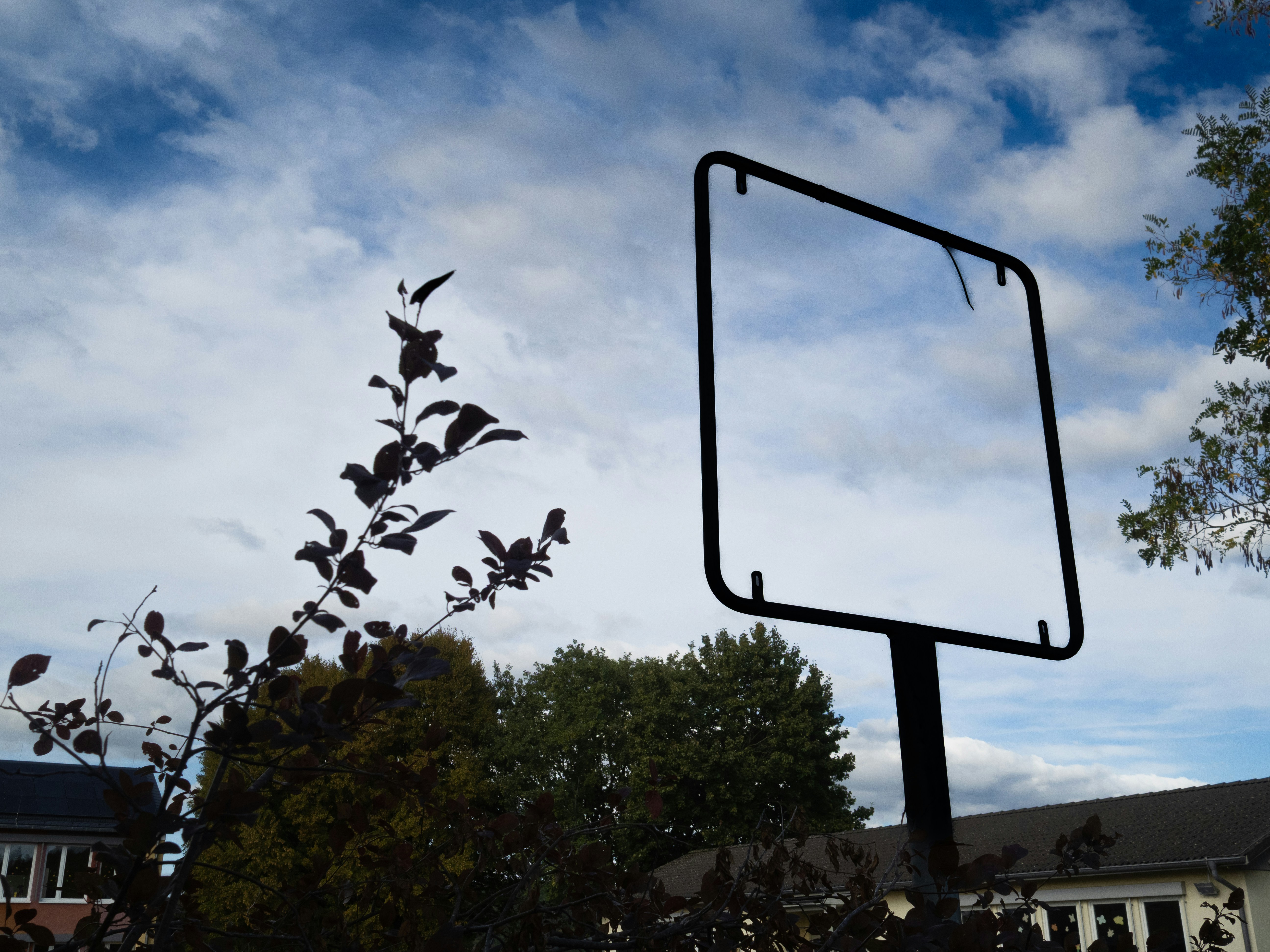 Leerer Wegweiser vor einem wolkigen blauen Himmel.