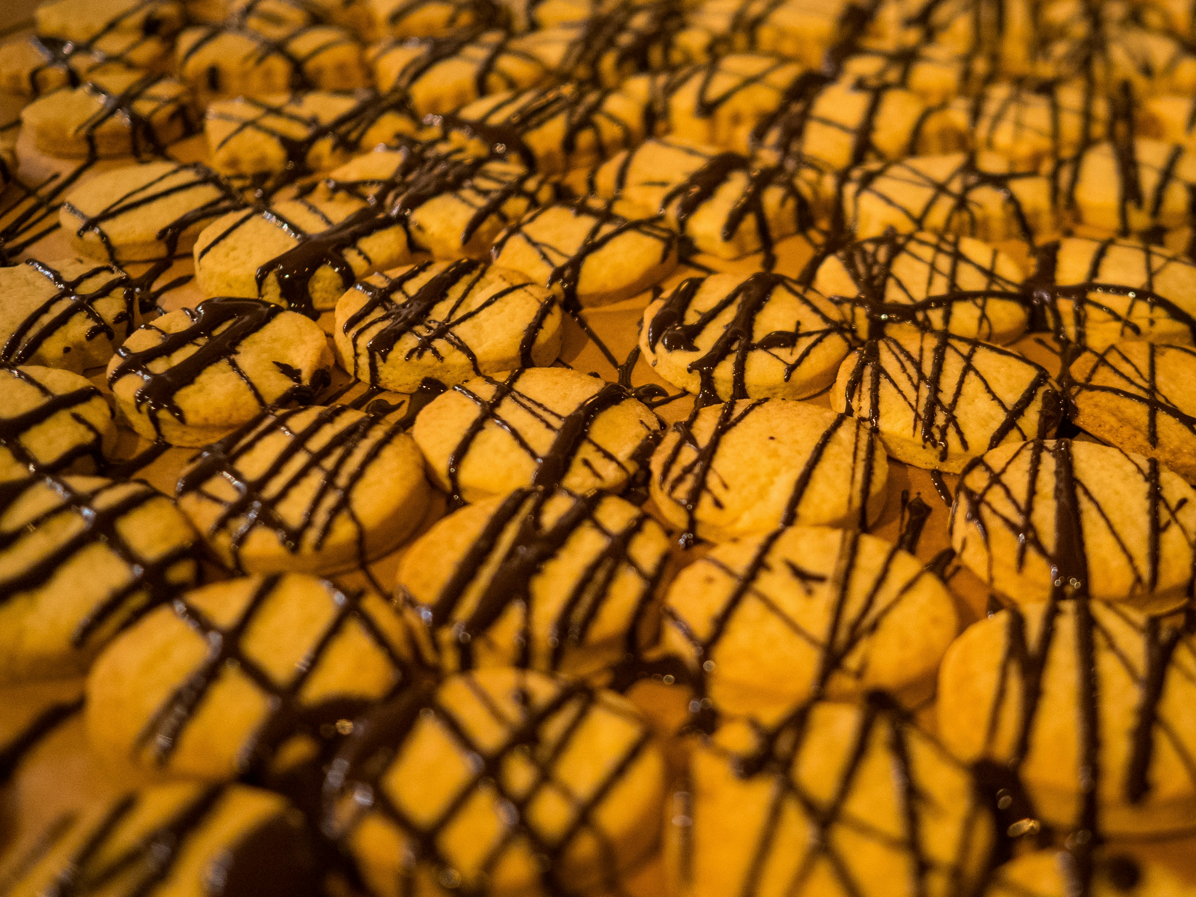 Reihen von Keksen, die mit dunkler Schokolade beträufelt waren