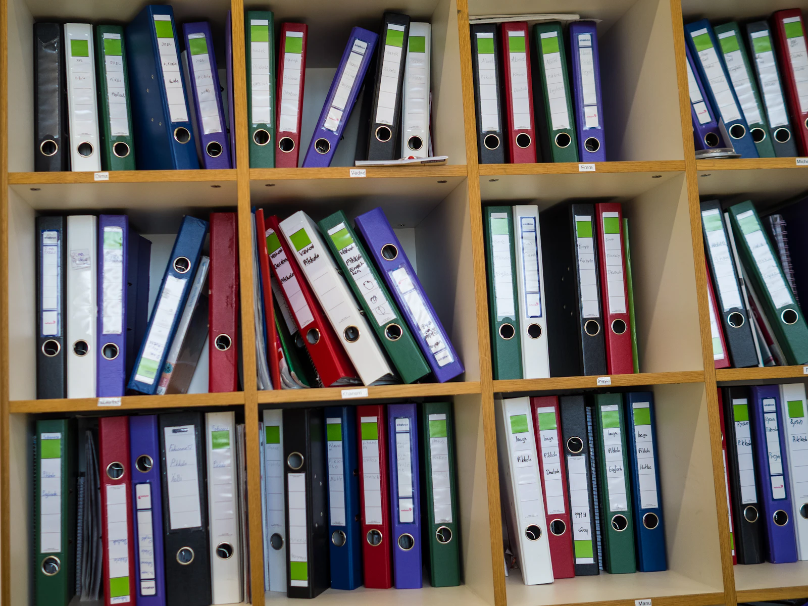 Regale gefüllt mit bunten Ordnern und Aktenmappen als Symbol für Organisation