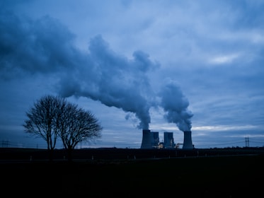 Cooling towers emitting steam under a cloudy sky