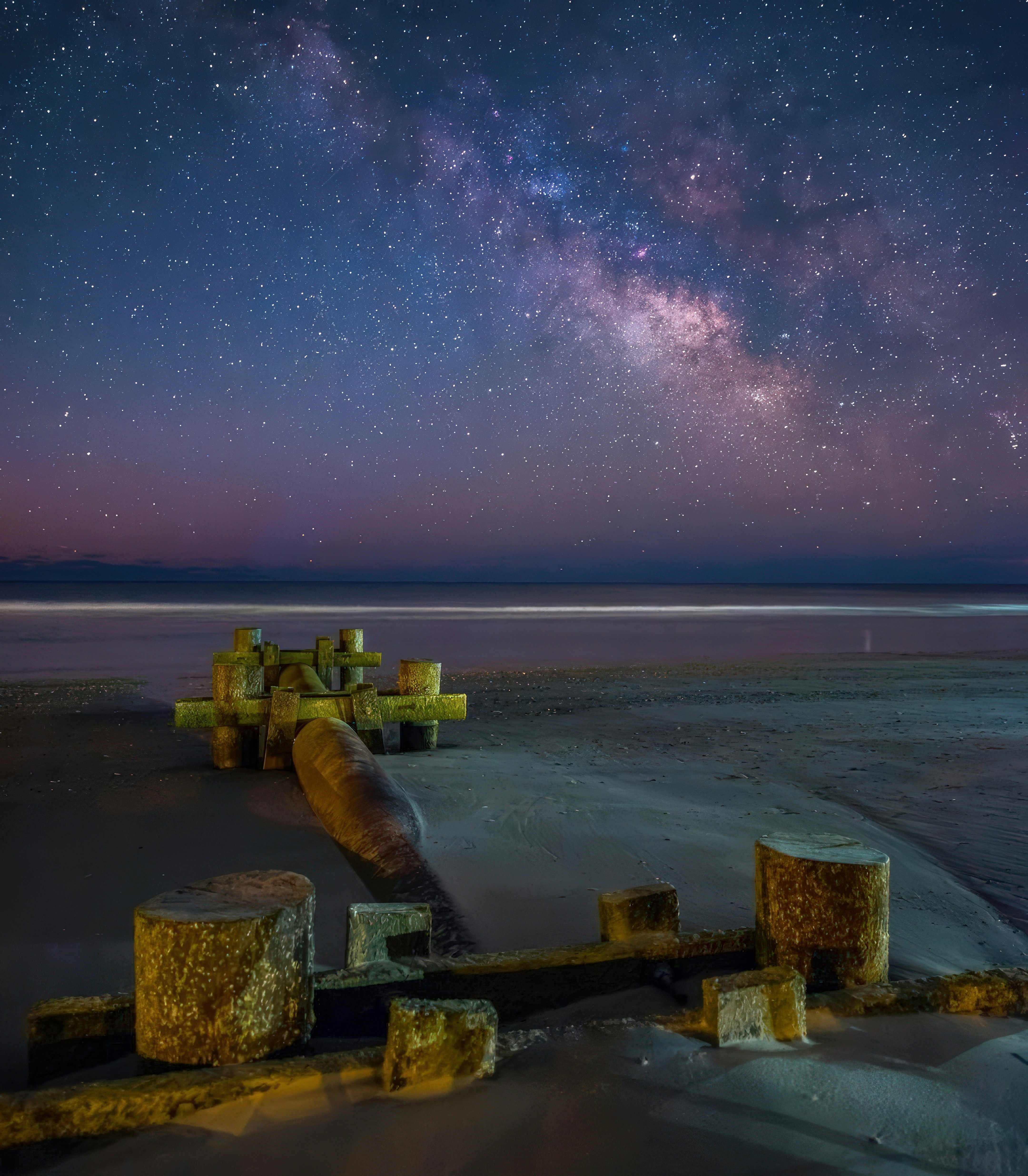 Milky way over a beach with old wooden structures