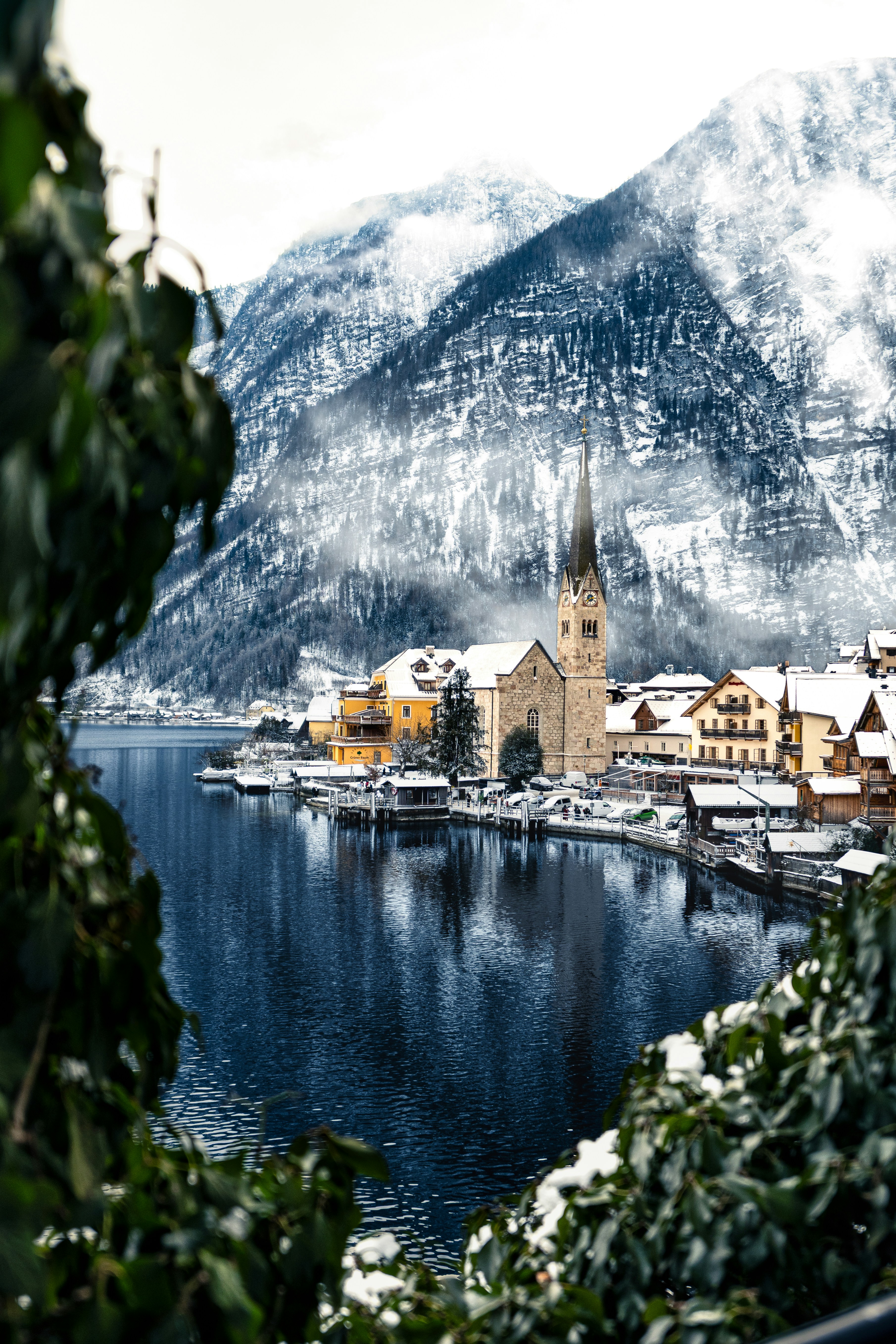Pueblo nevado junto a un lago con montañas detrás.