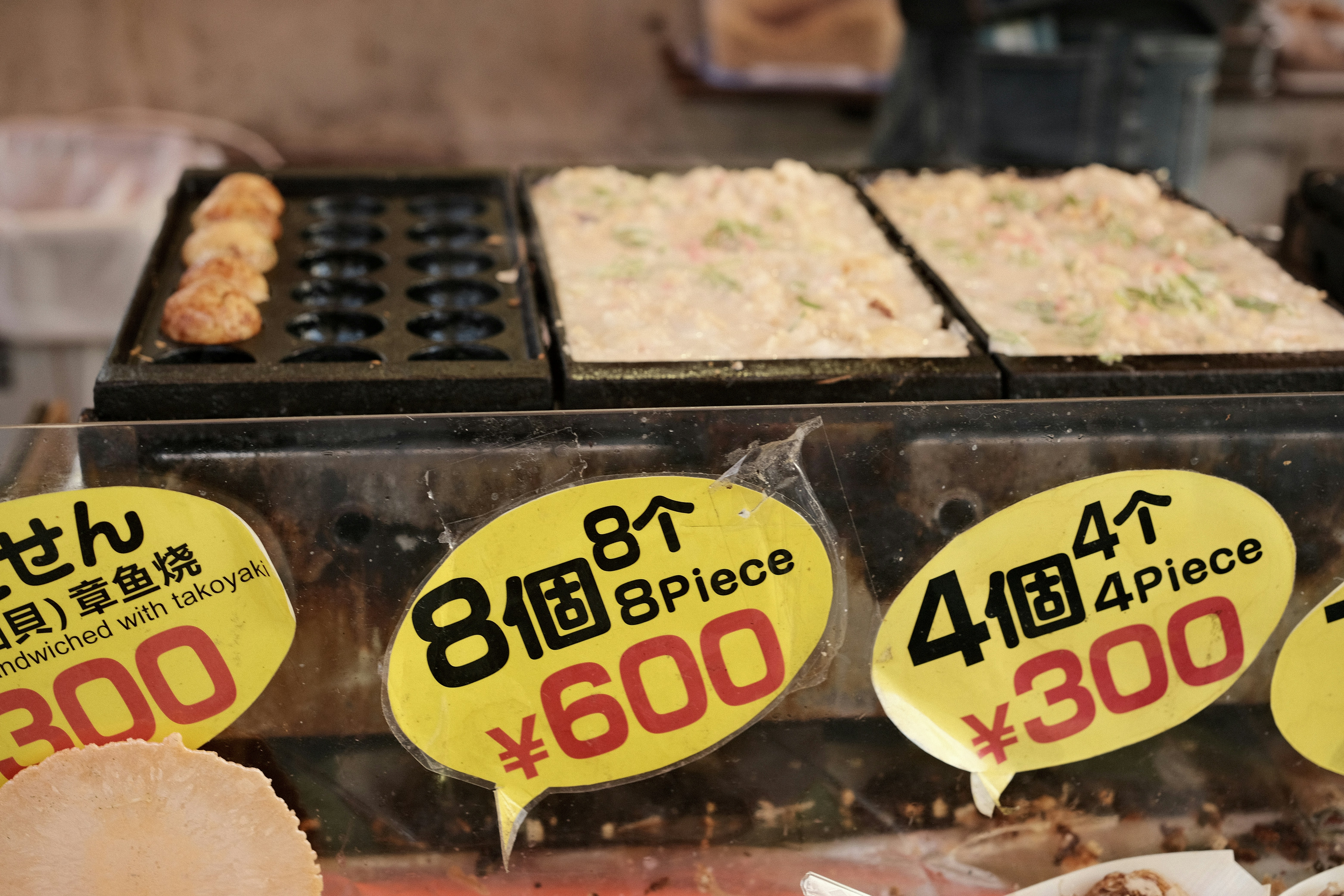 Close-up of a Japanese restaurant's outdoor display of plastic food models with prices