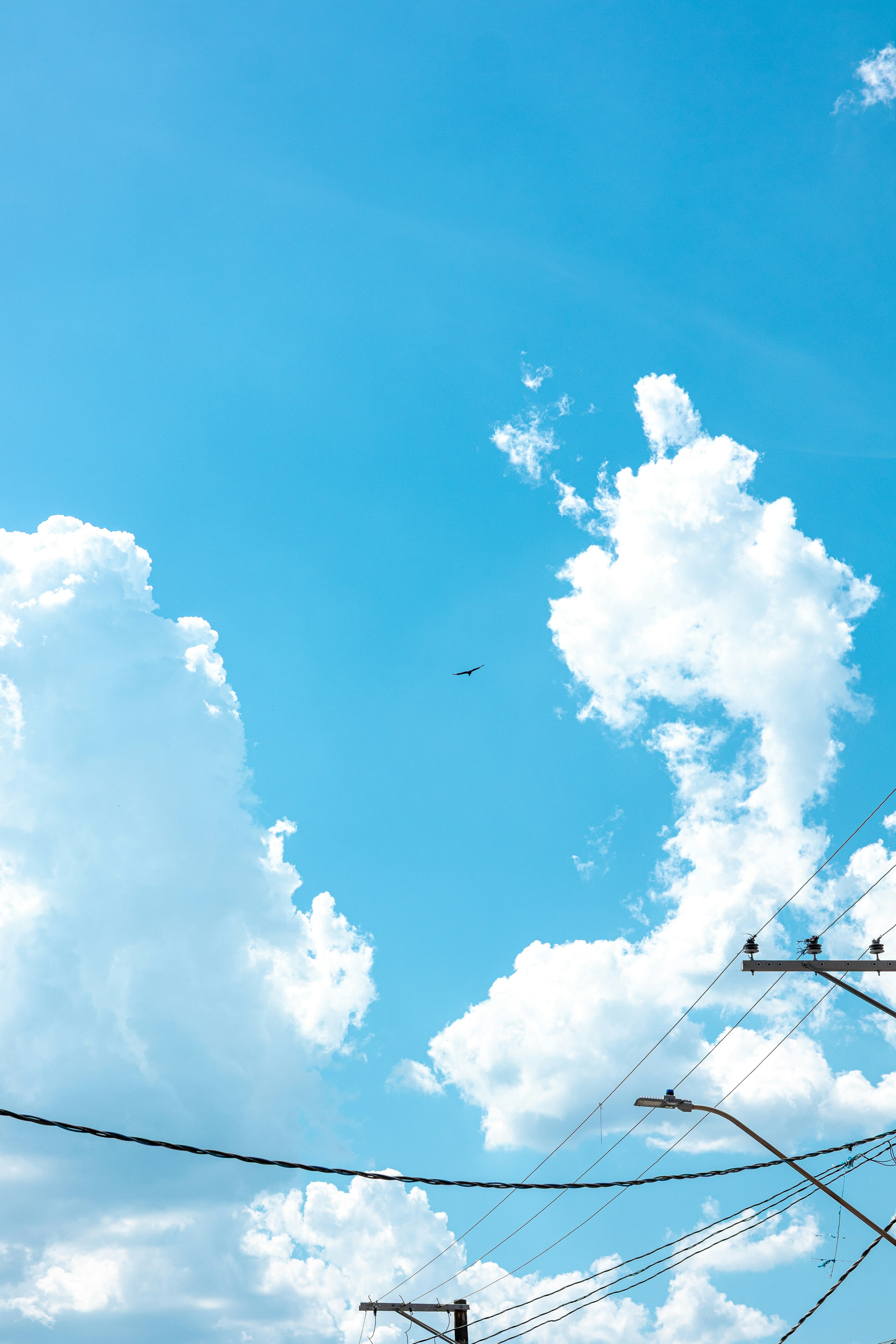 Airplane flying through fluffy clouds against blue sky.