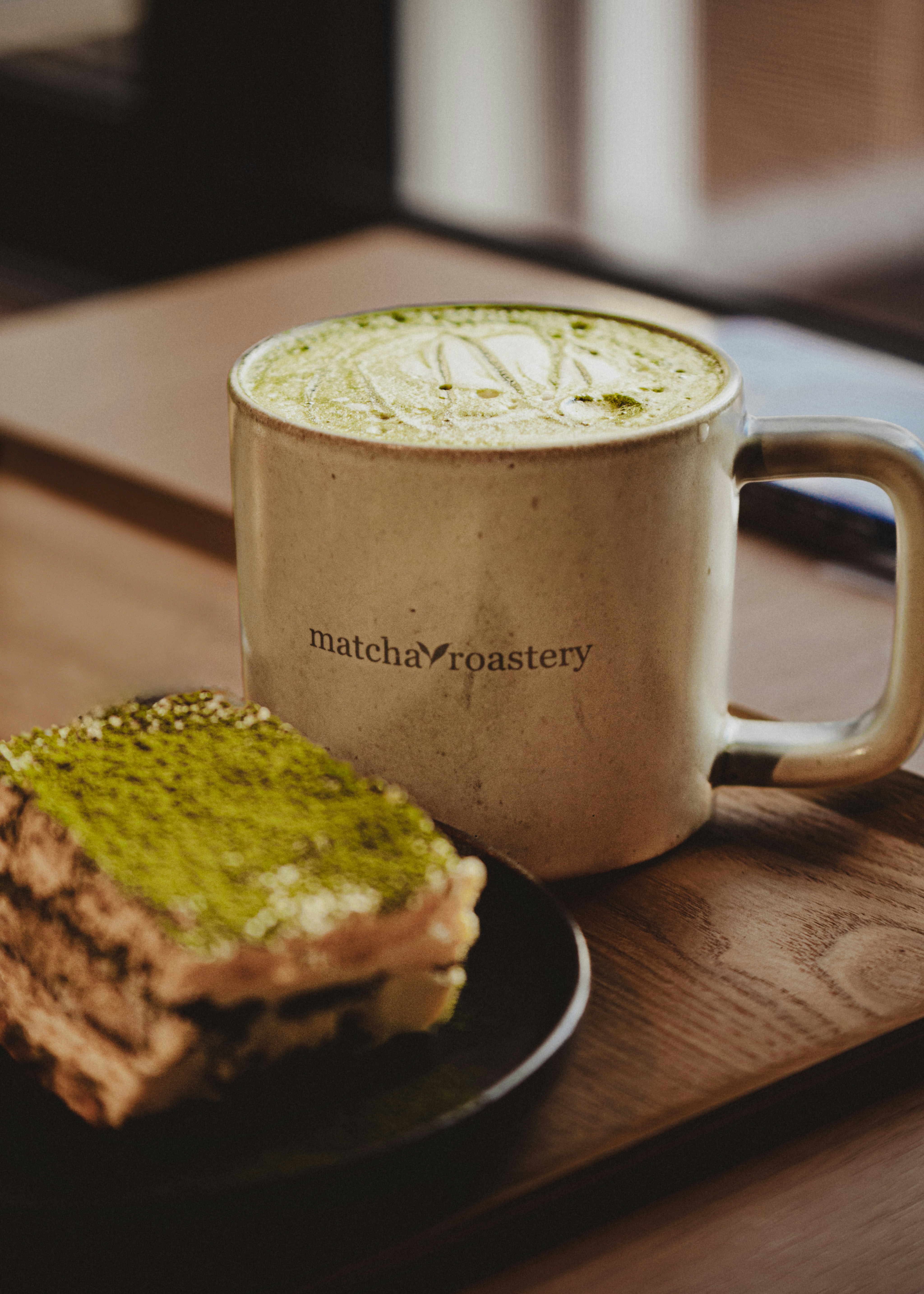 Matcha Latte und geschichtetes Dessert auf einem Holztablett