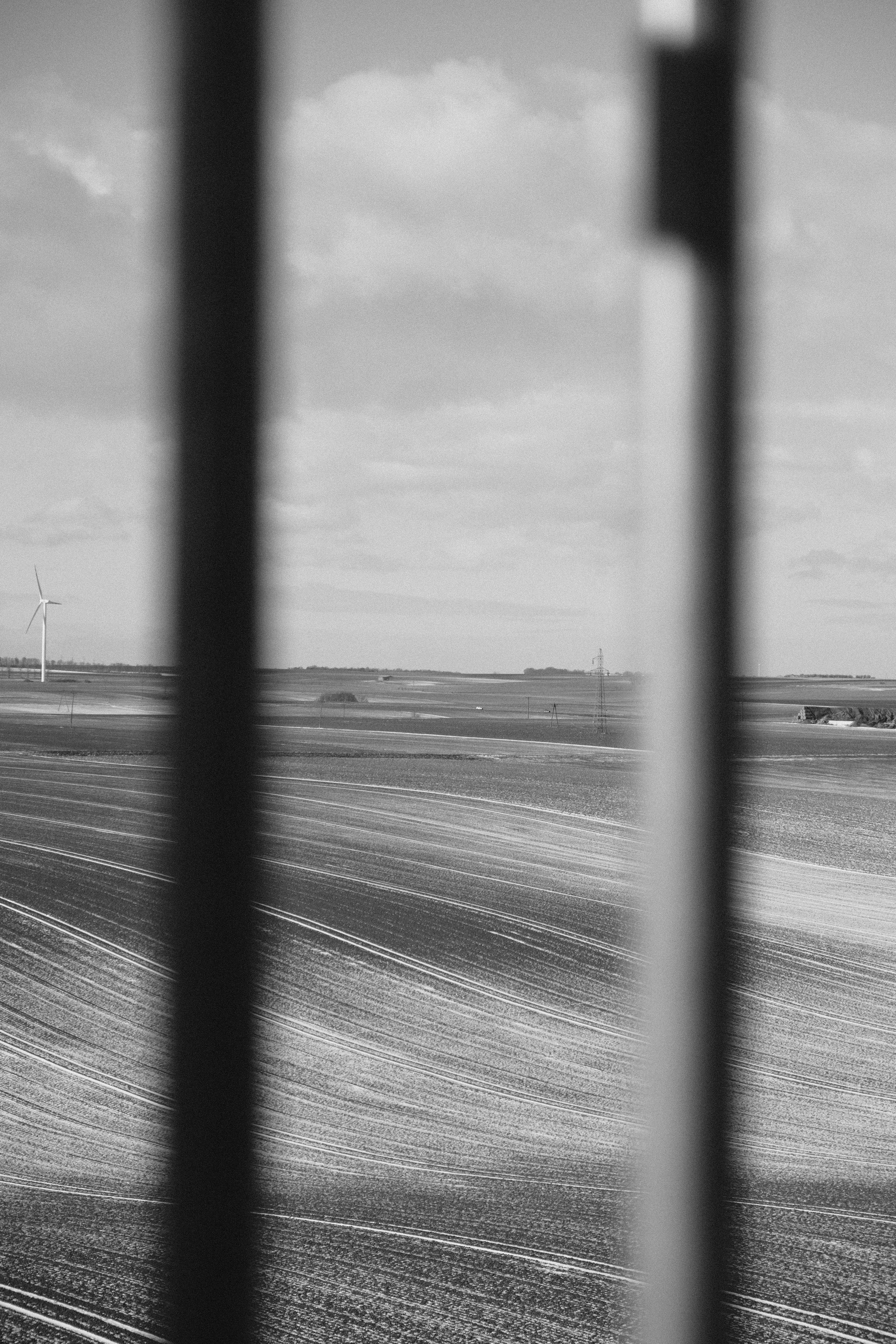 Wind turbine in a vast agricultural field under clouds