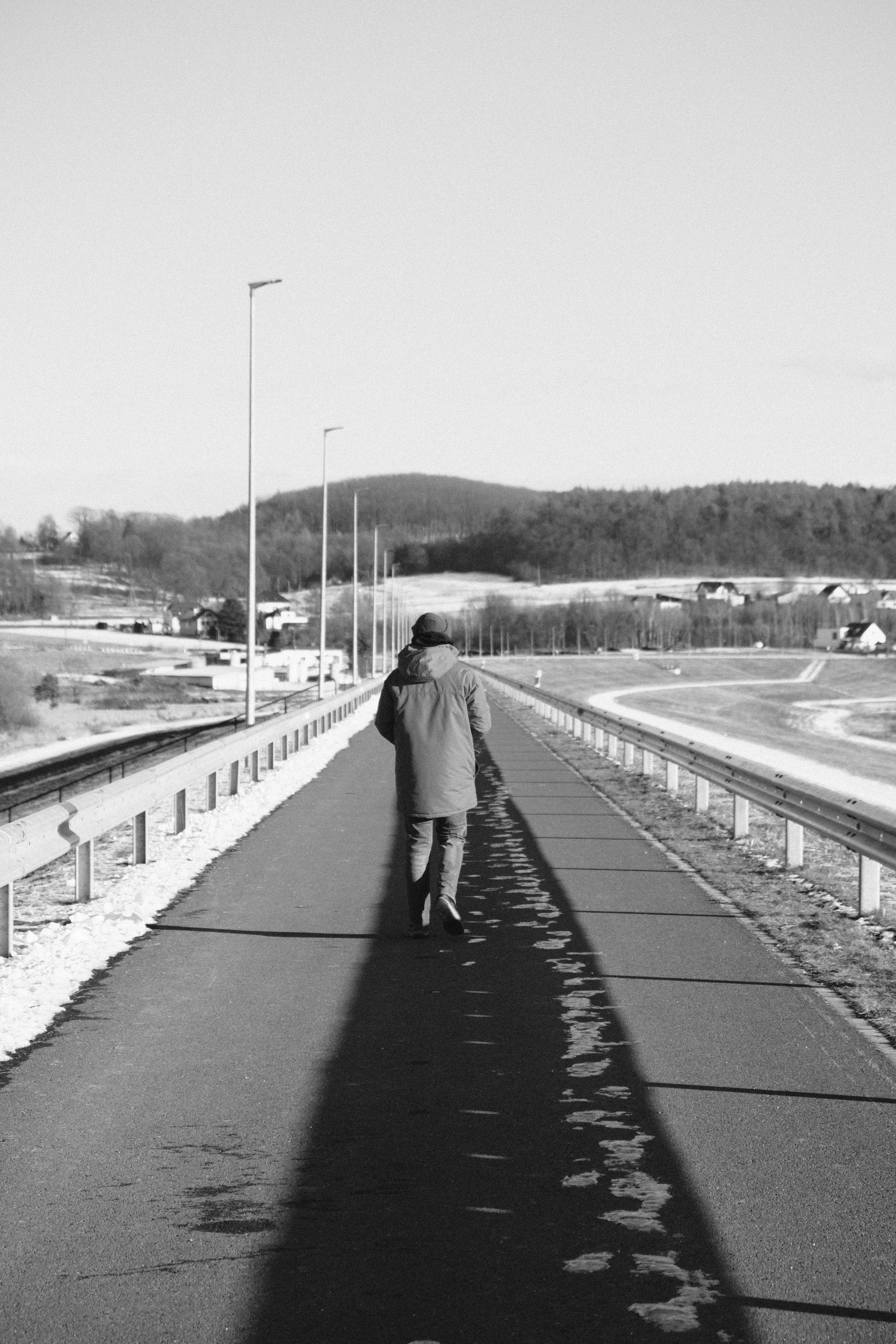 Person walking down a long, straight road