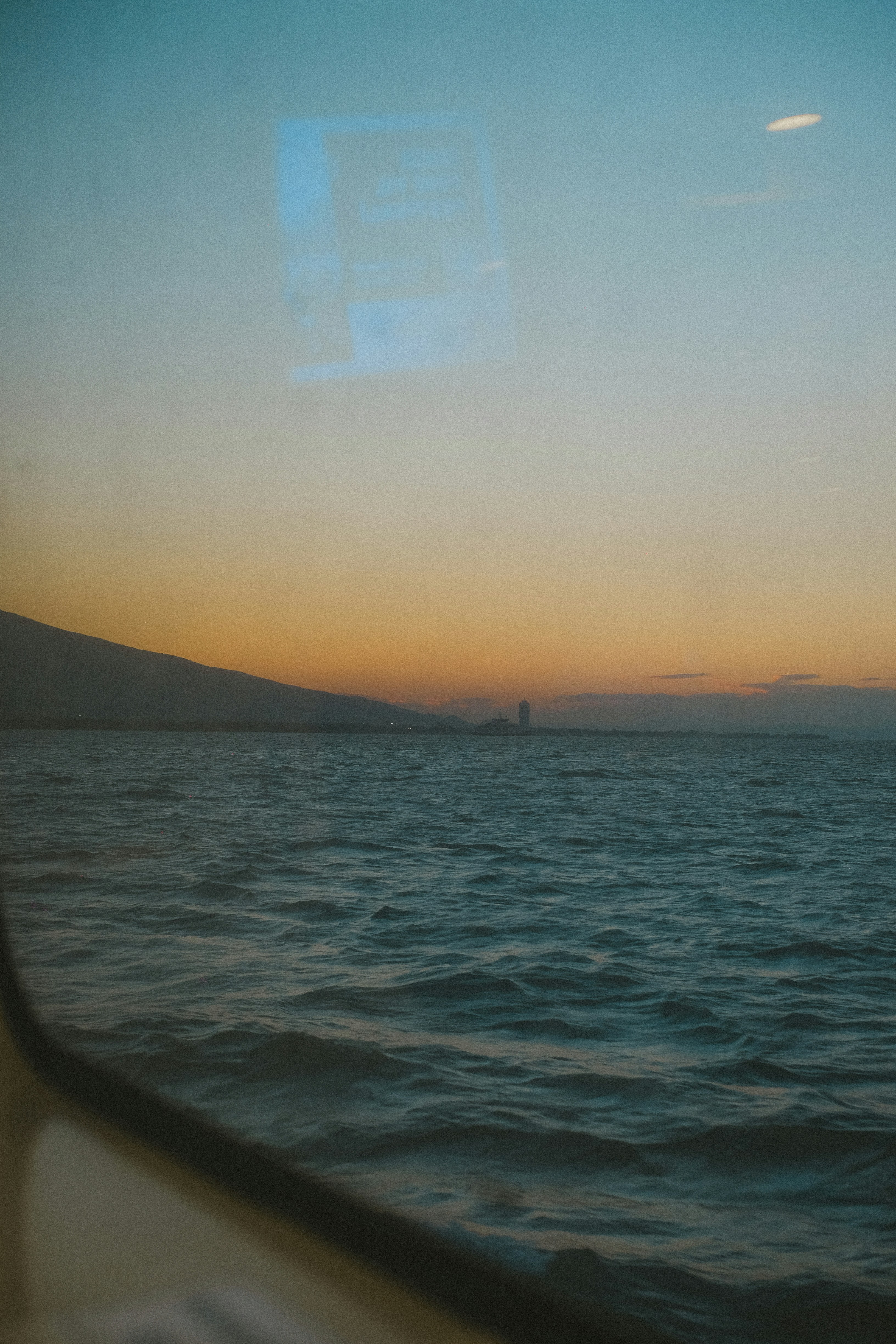 Calm ocean waves under a sunset sky.