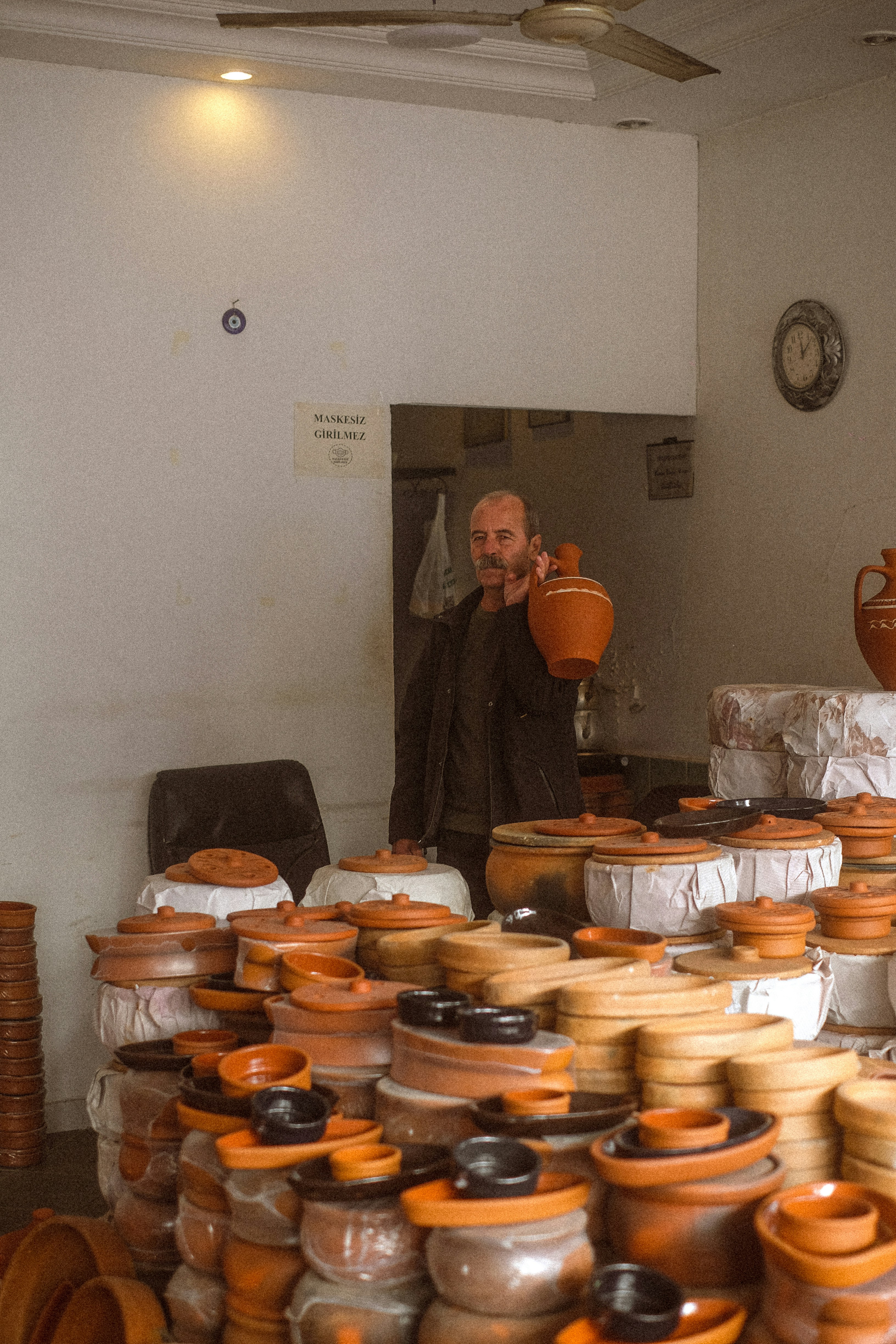Man holding a clay pot in a shop
