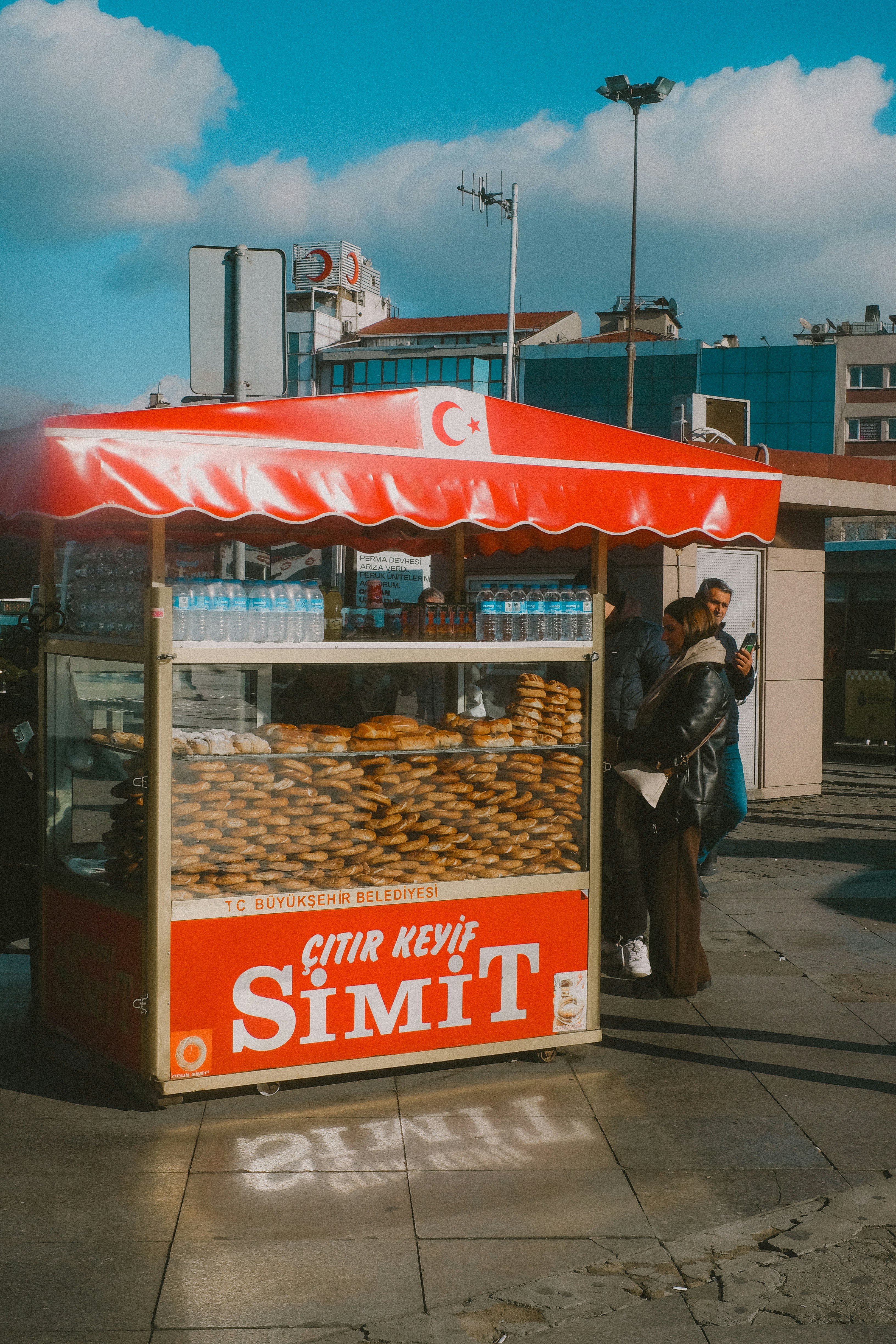 Street food stand selling simit with turkish flag.