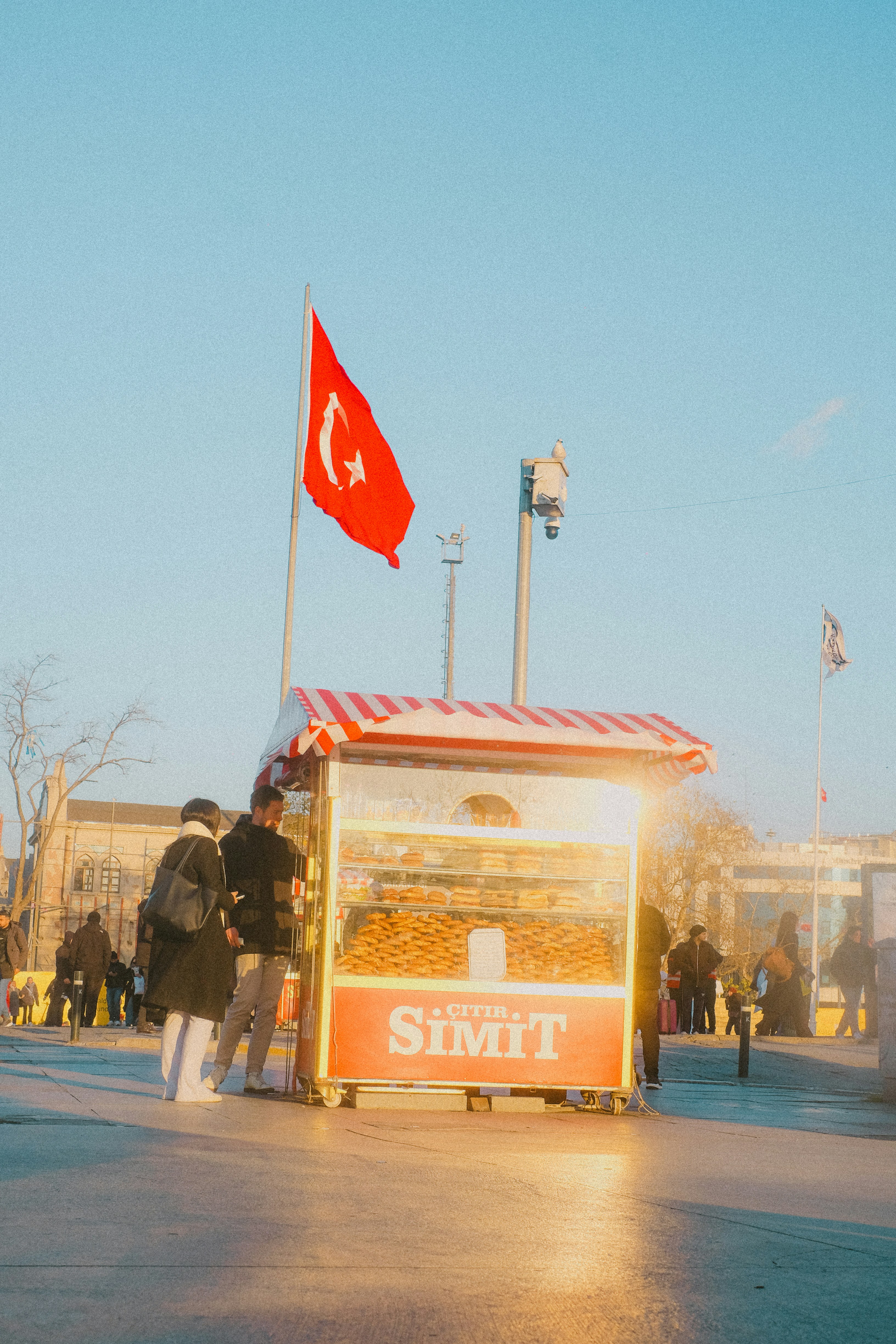 Turkish flag flies over a simit stand.