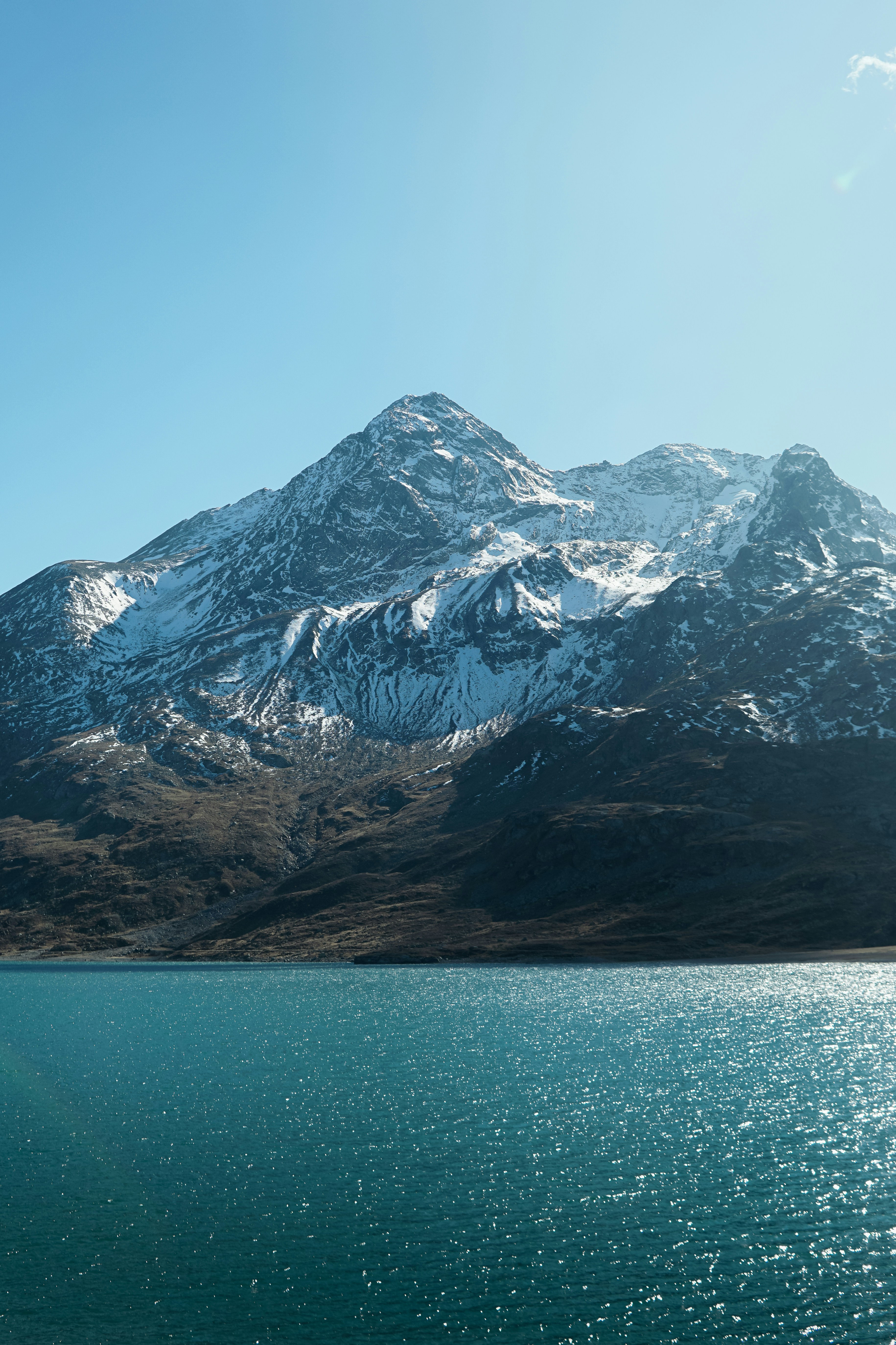 Snow-capped mountain range overlooking a sparkling blue lake