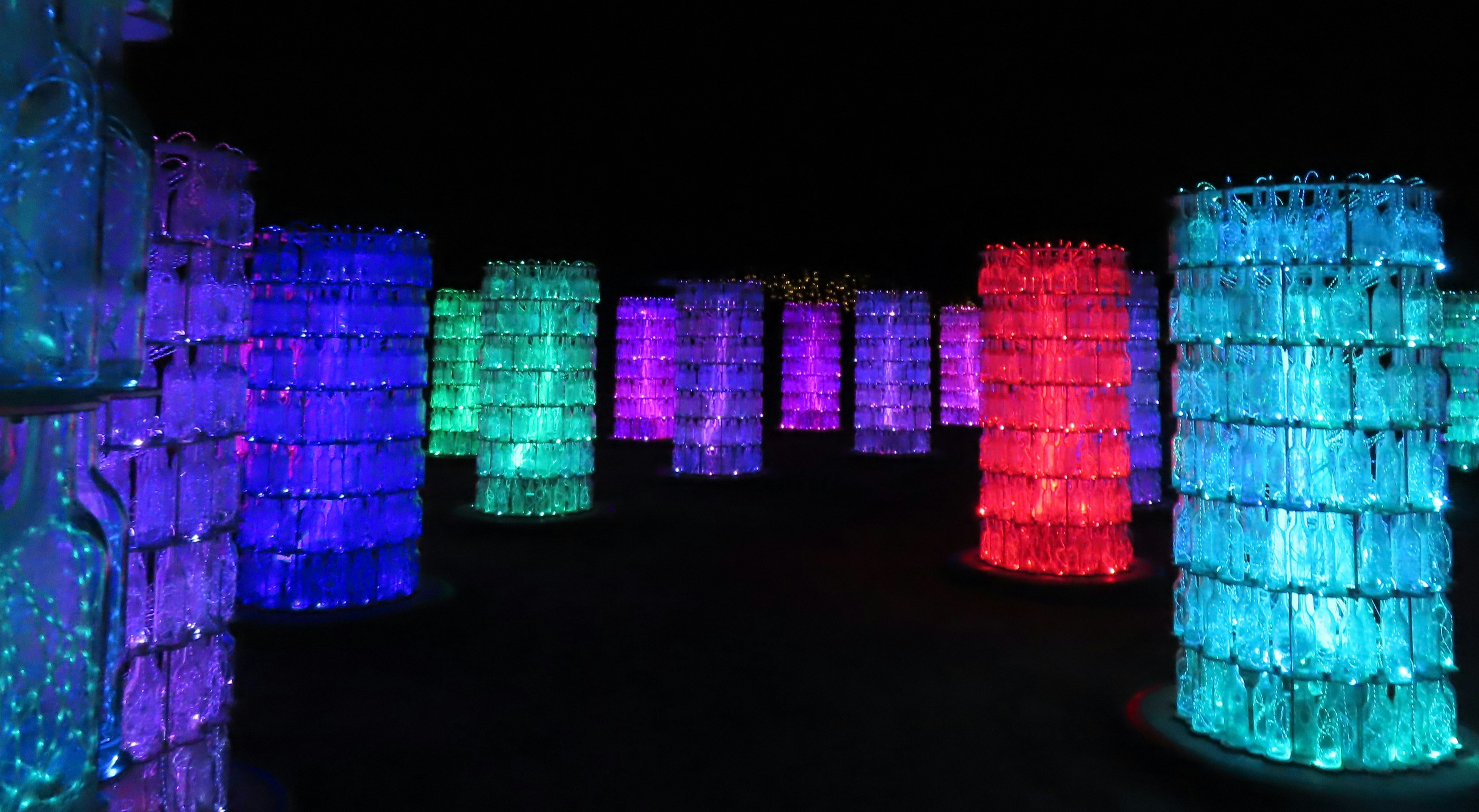 Illuminated columns of colorful lights at night.