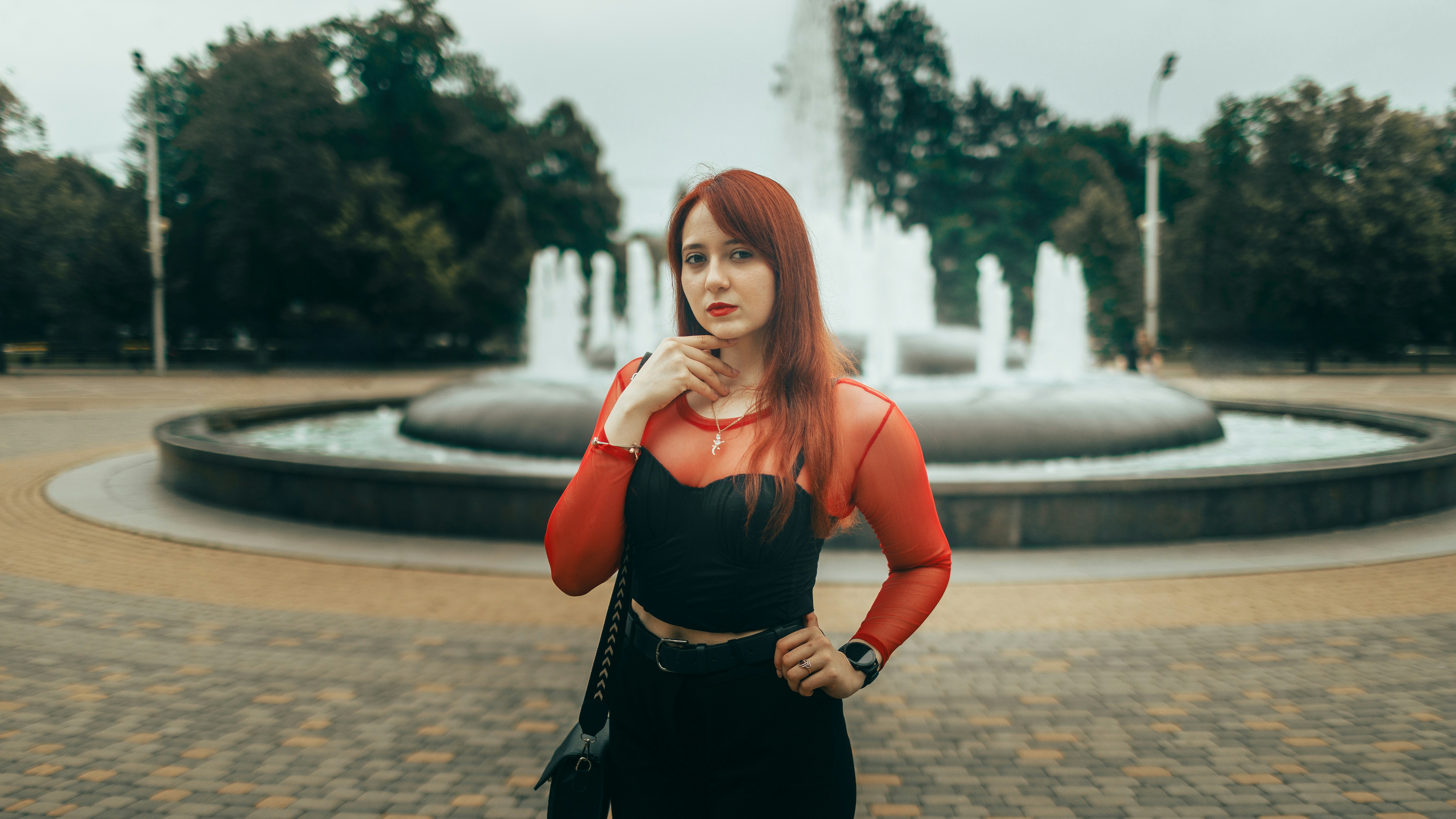 Woman in red and black standing by a fountain
