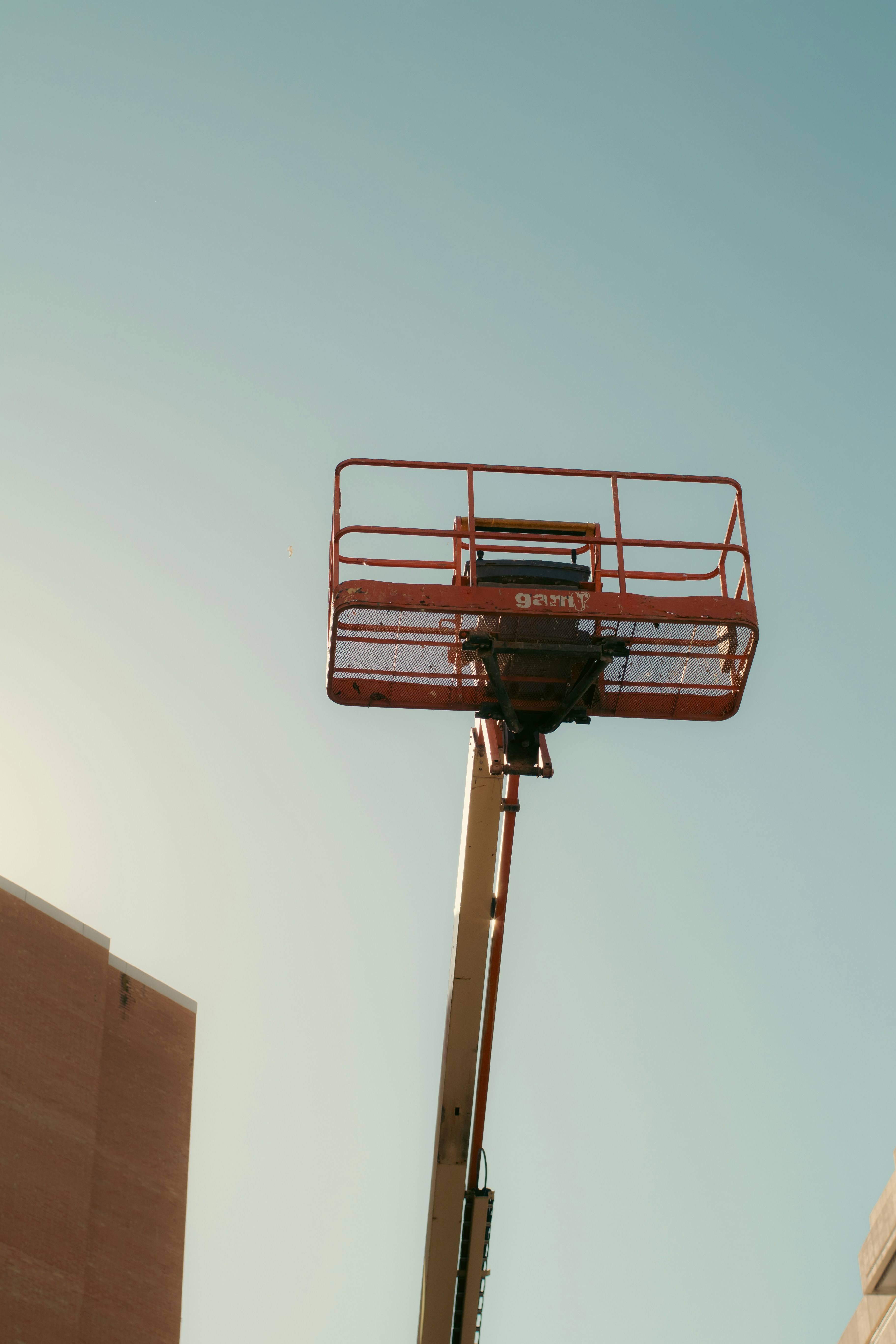 Oranger Boom-Liftkorb gegen klaren Himmel
