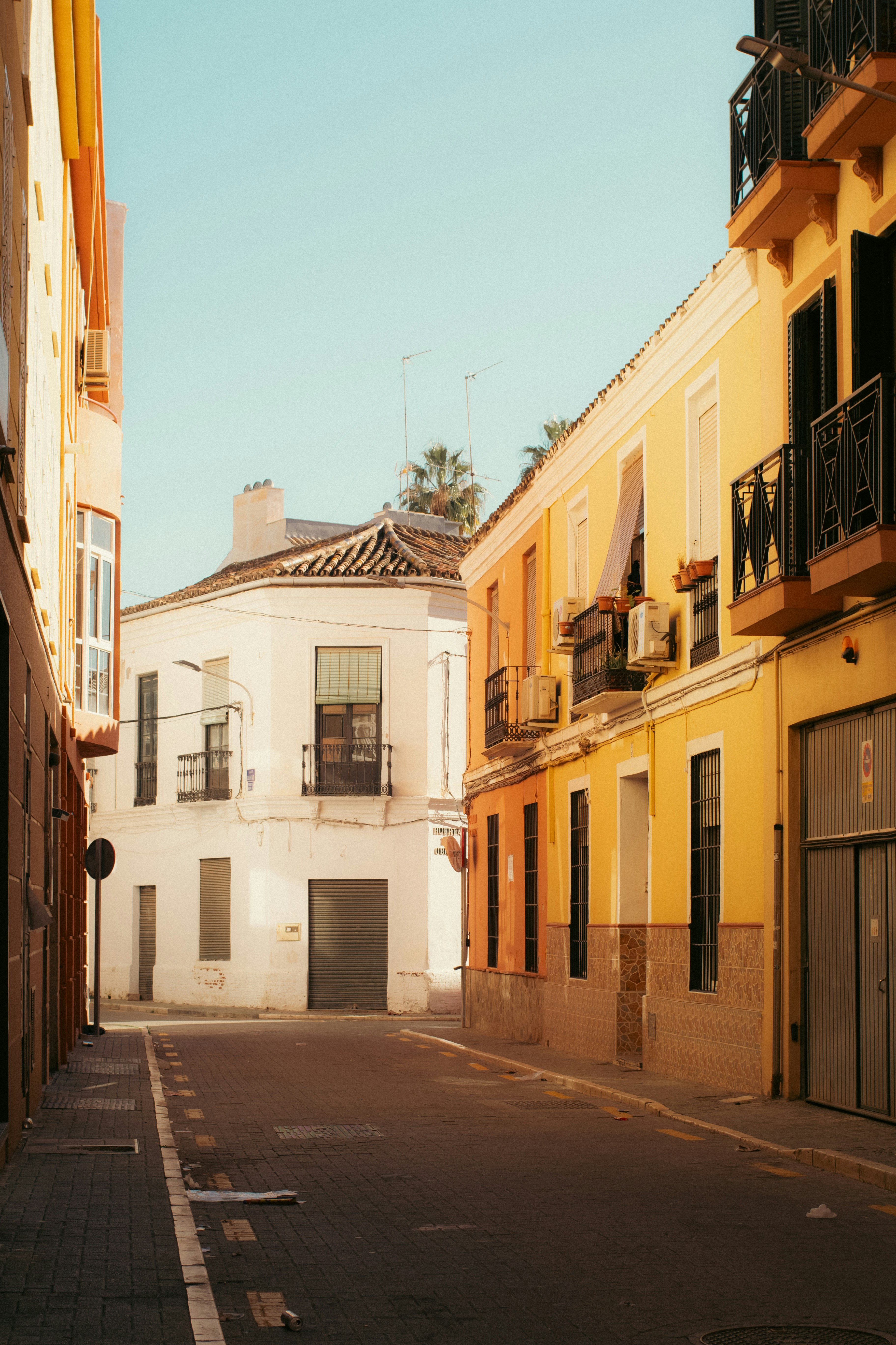 Bunte Gebäude säumen eine schmale Straße unter klarem Himmel.