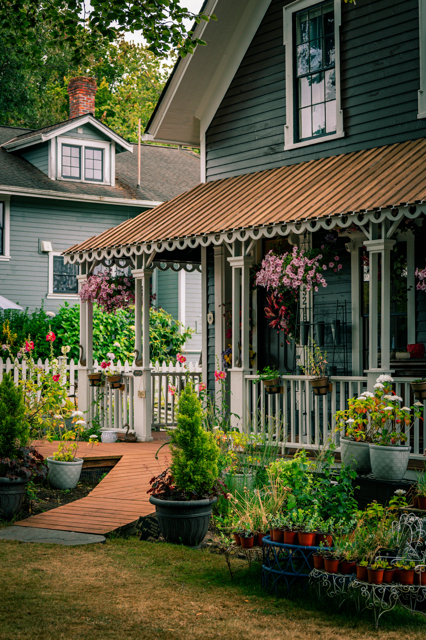 A house with a white picket fence and flowers in the front yard