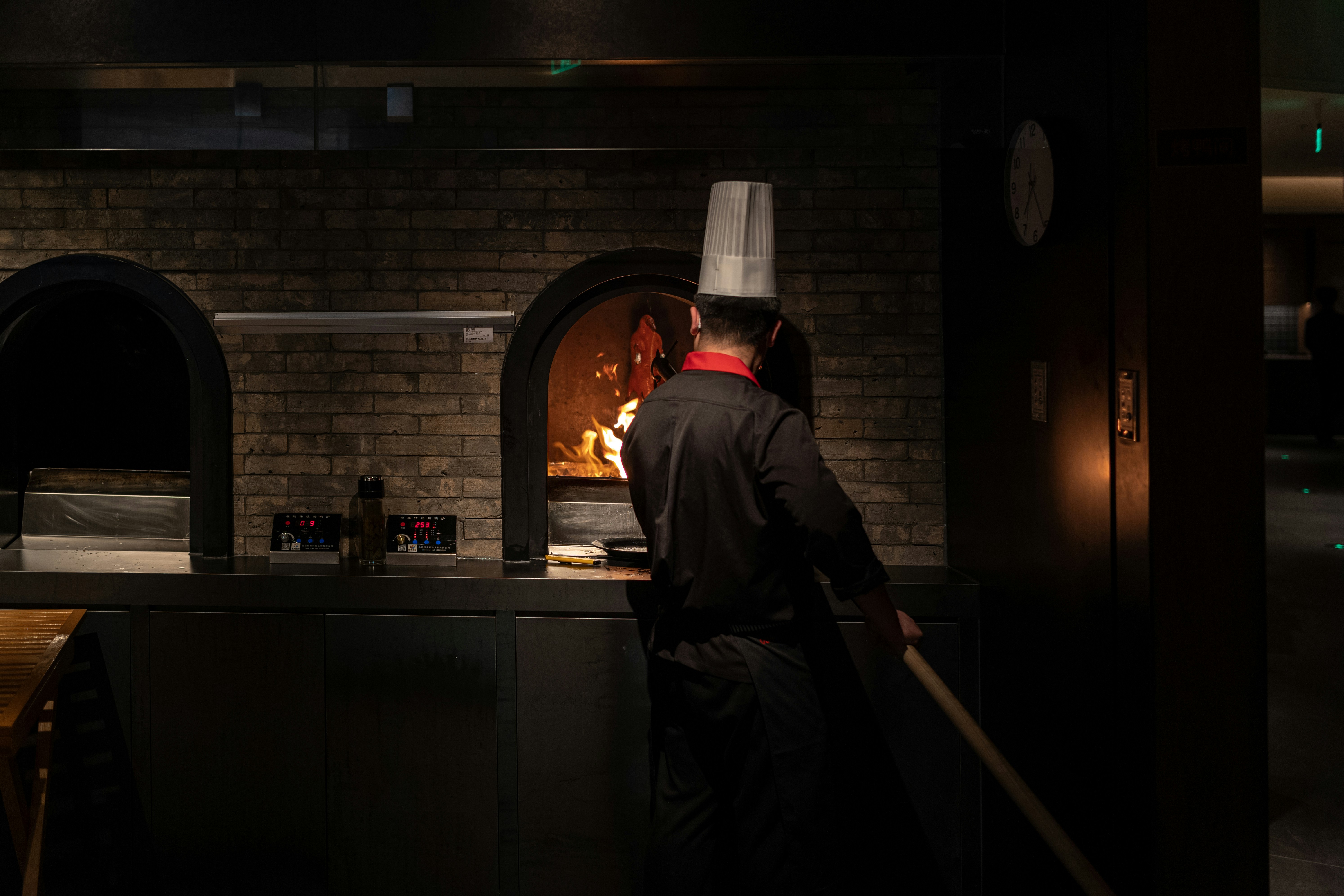 Chef placing pizza in a brick oven