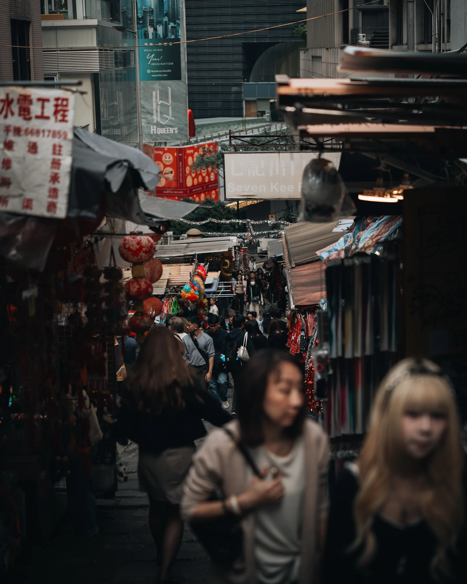 Crowd of pedestrians walking through a busy street market lined with vendor stalls