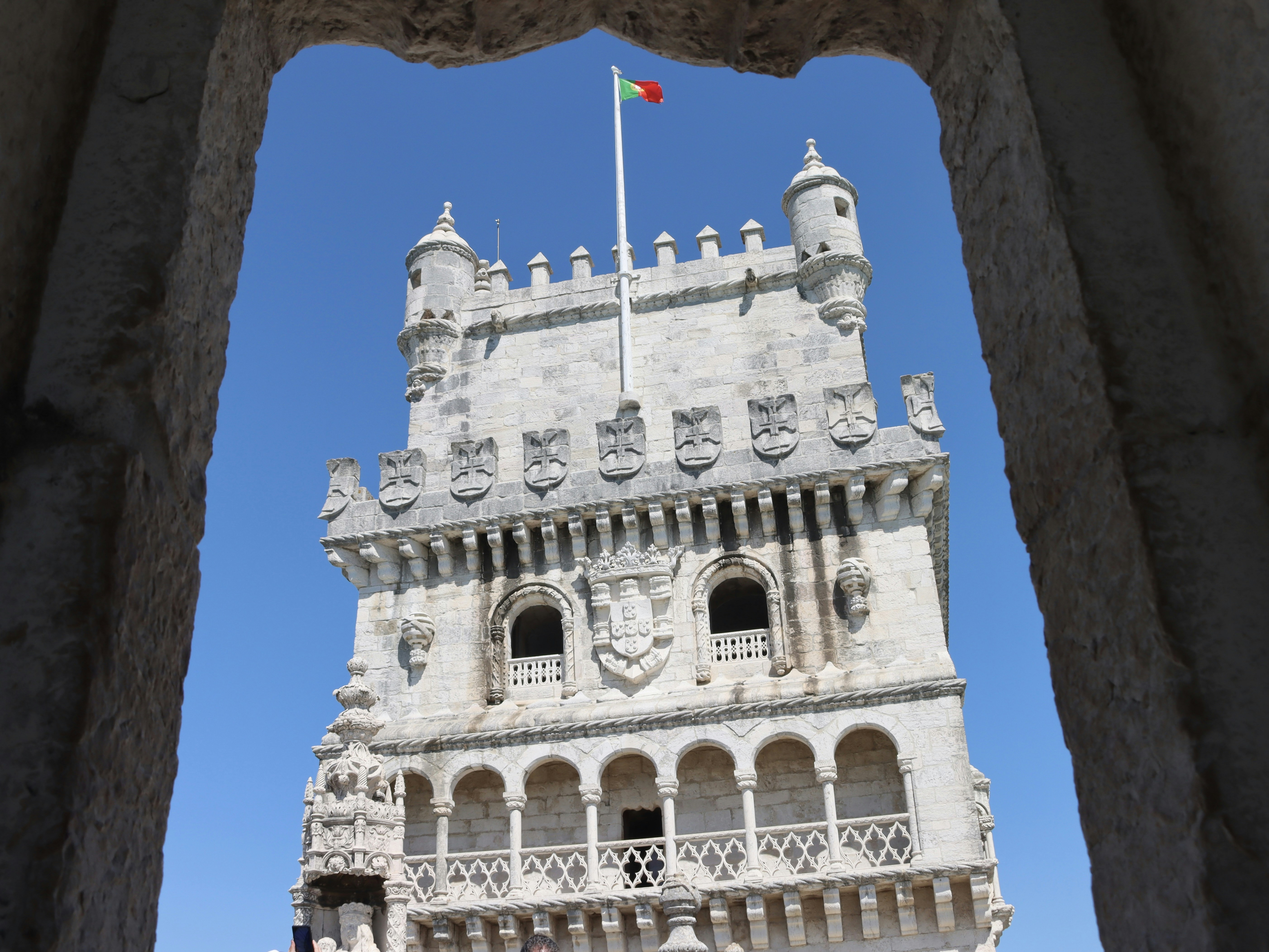 Torre de piedra con bandera contra un cielo azul