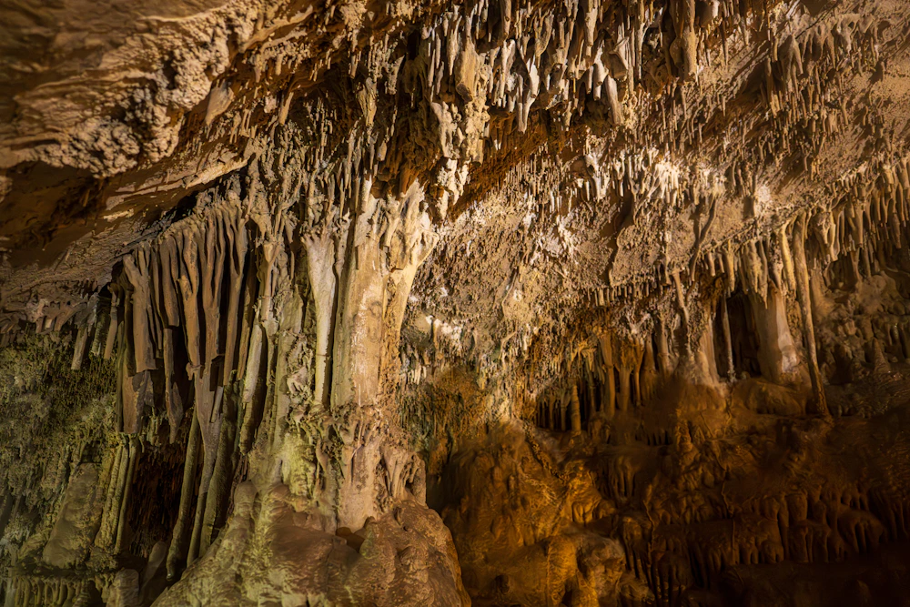 Stalactites and stalagmites inside a cave · illustrative photograph