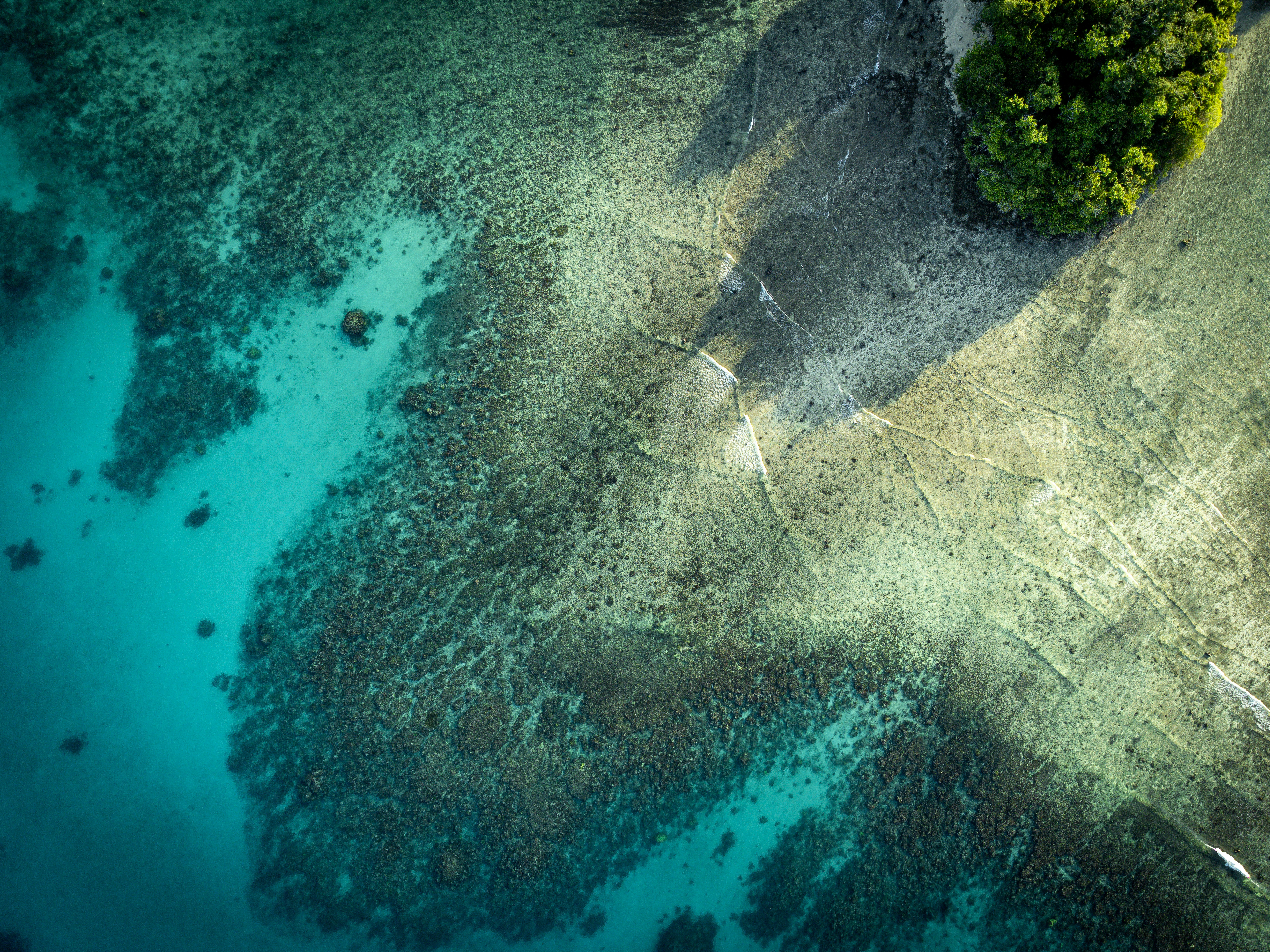Aerial view of clear turquoise water over coral reef.
