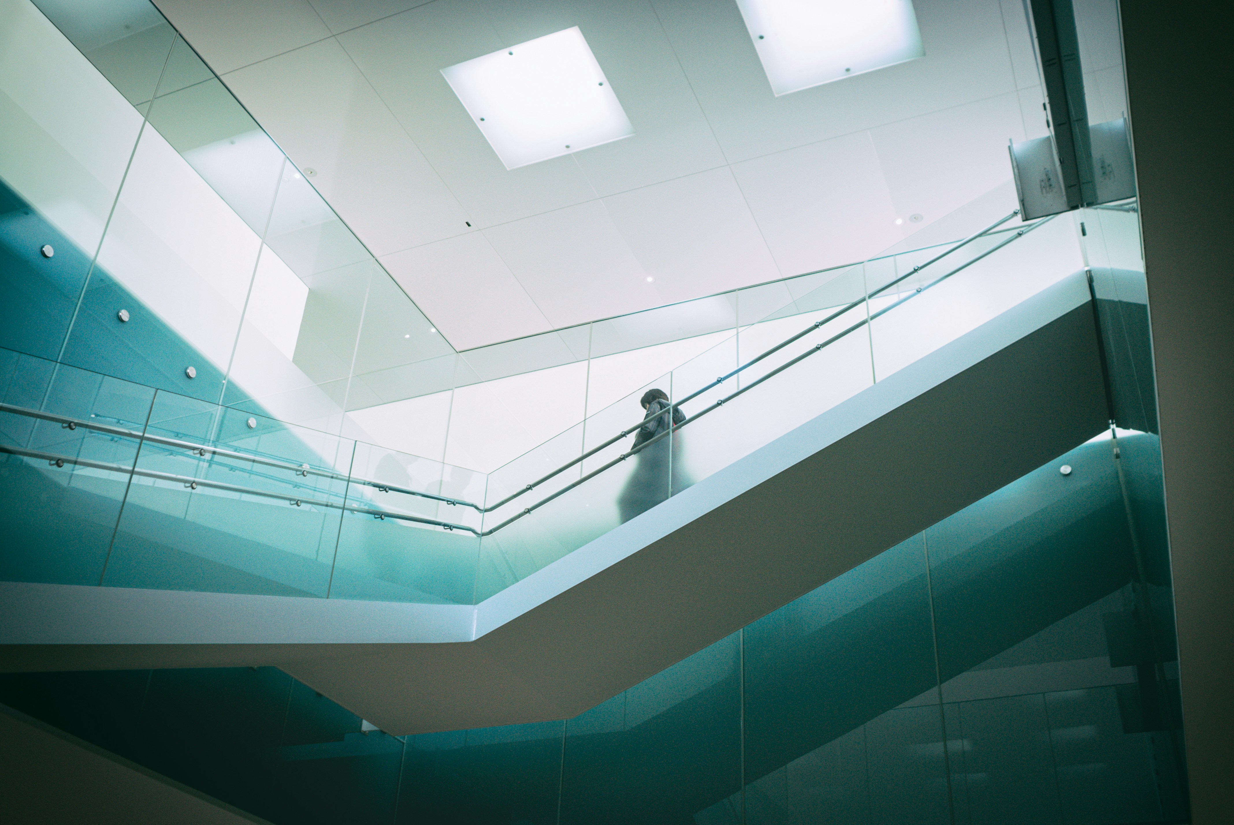 Person walking up modern glass staircase