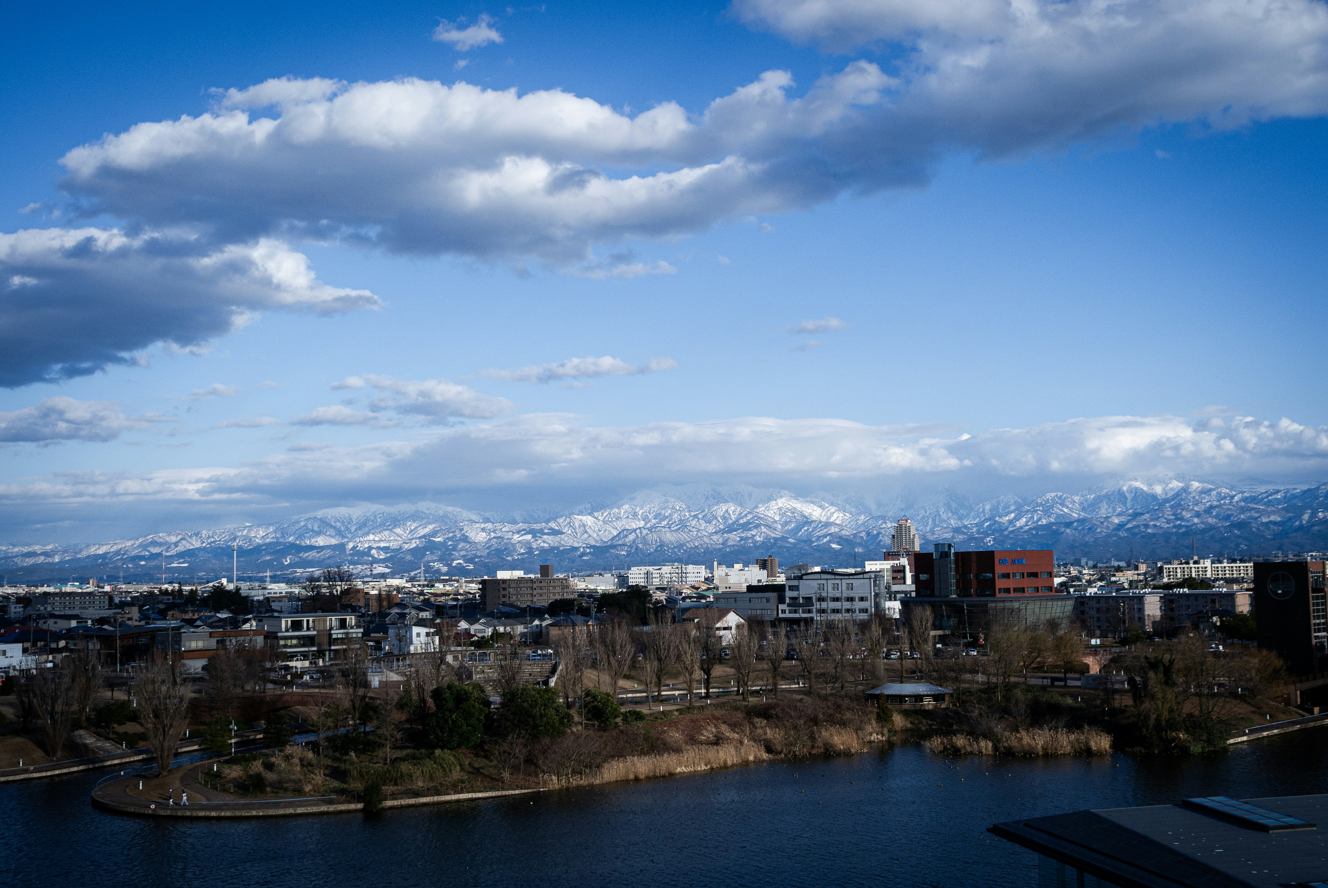 City skyline with snow-capped mountains in the distance