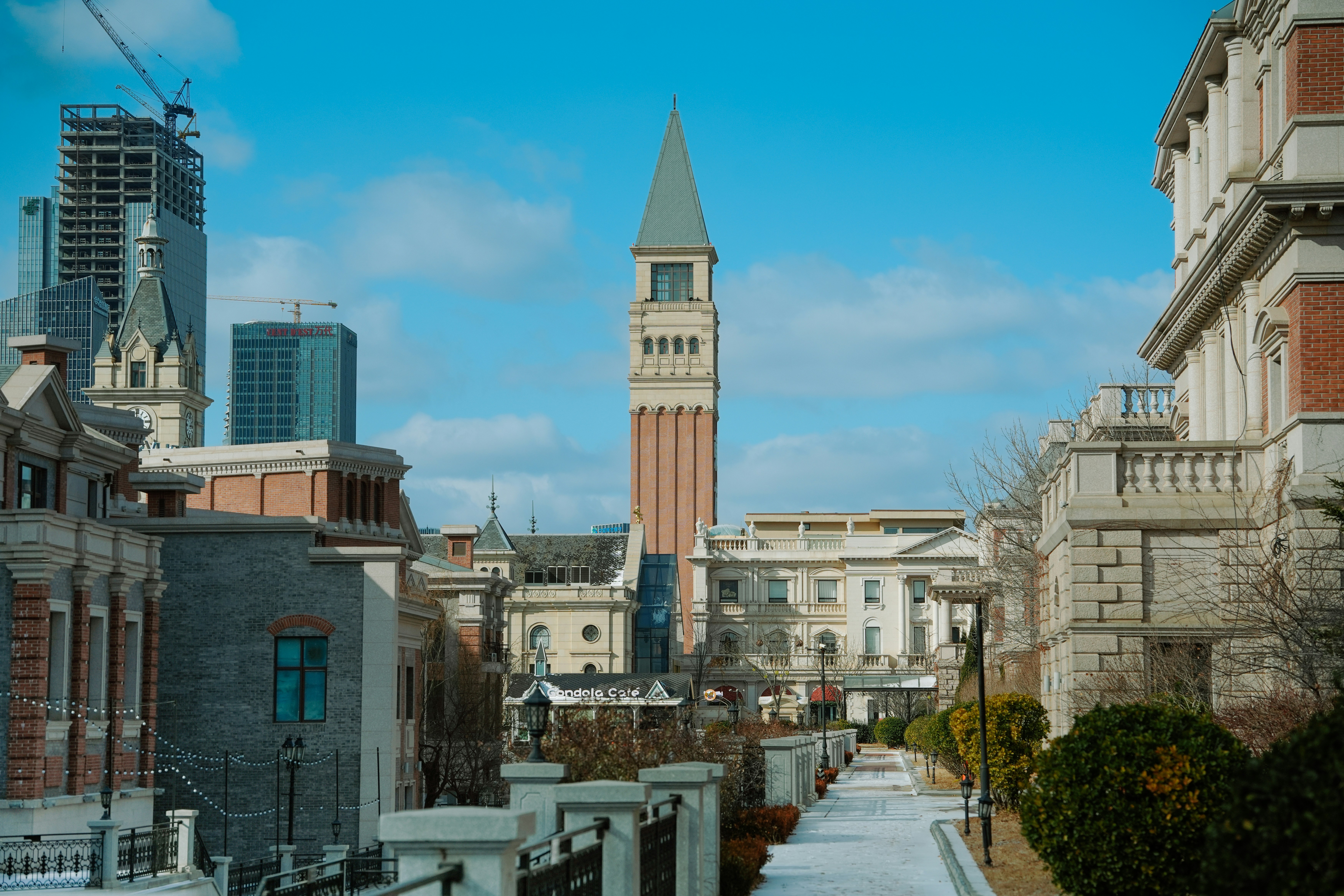 Tall clock tower building with modern skyscrapers behind.