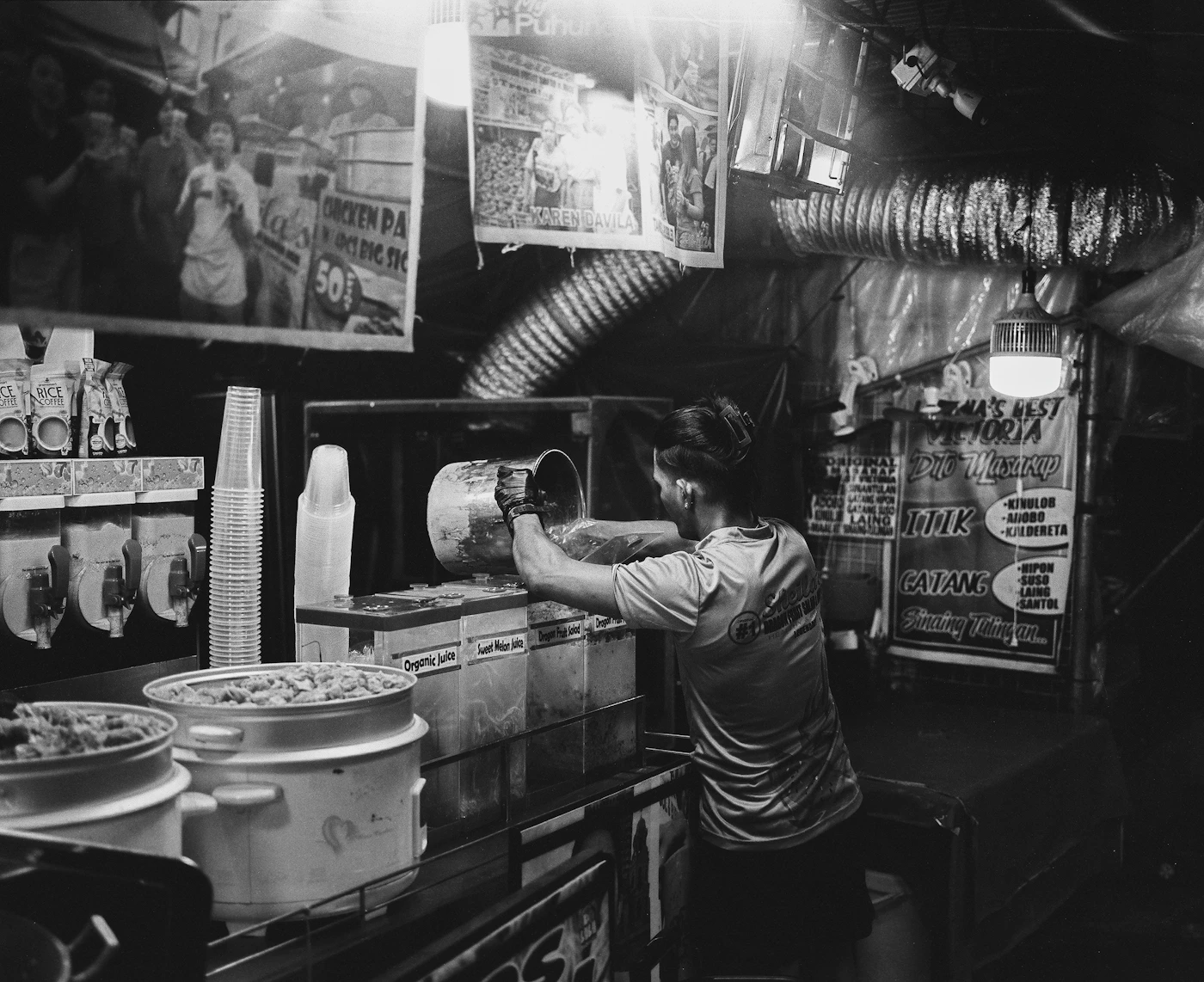 Vendor working at a street-food stall, black and white