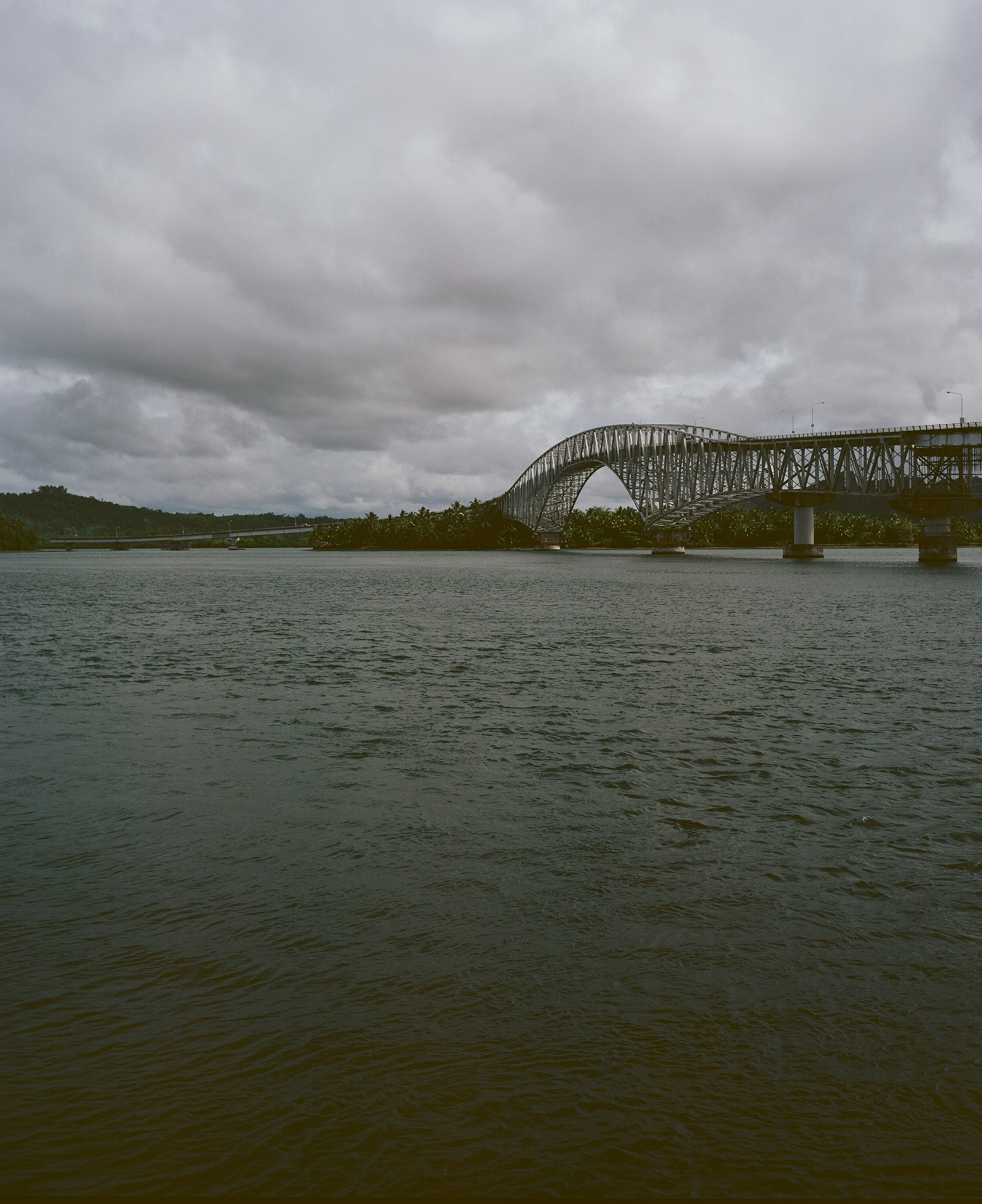 A large metal bridge over a wide river