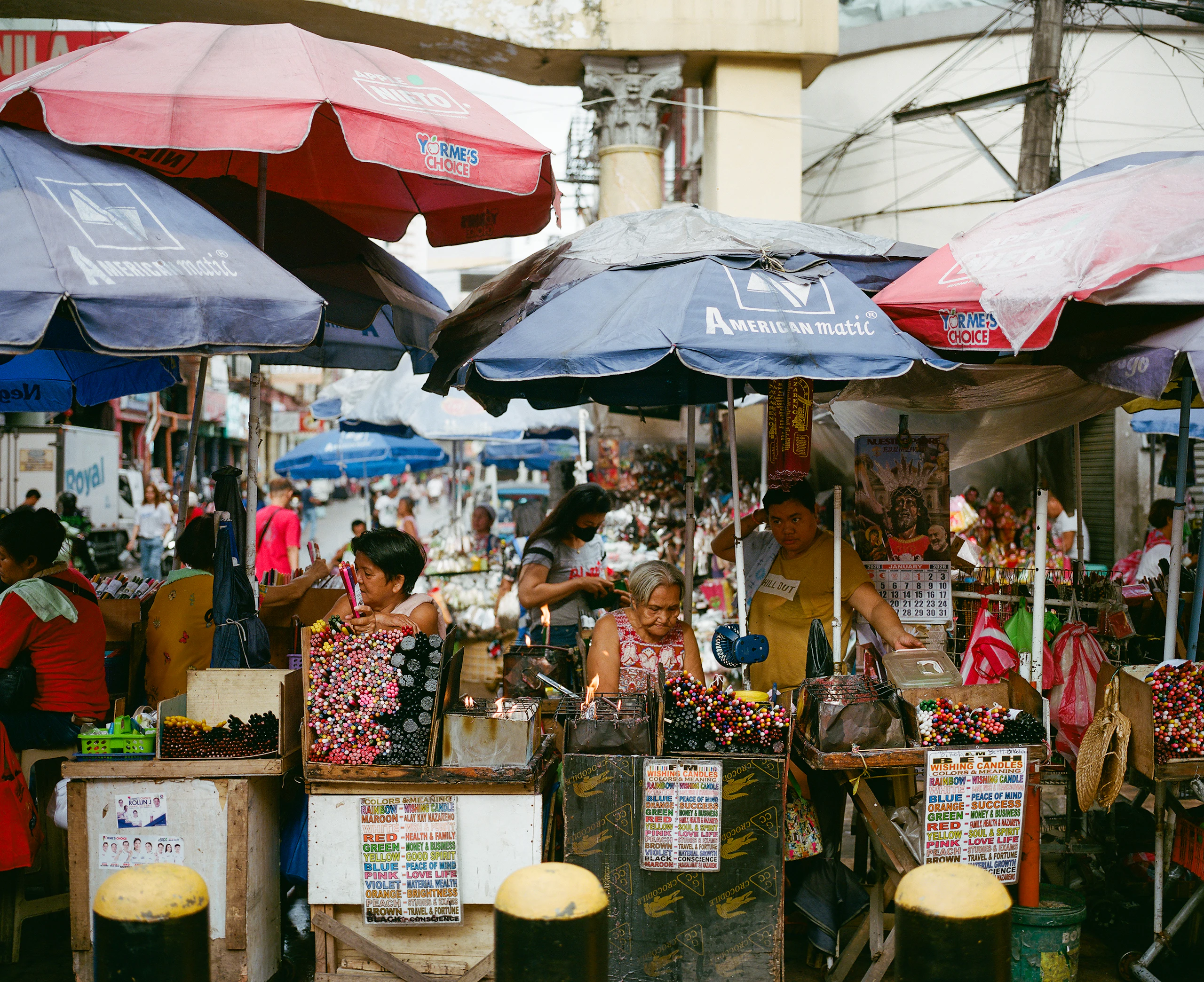 Peso notes and coins on a market stall counter beside mangoes