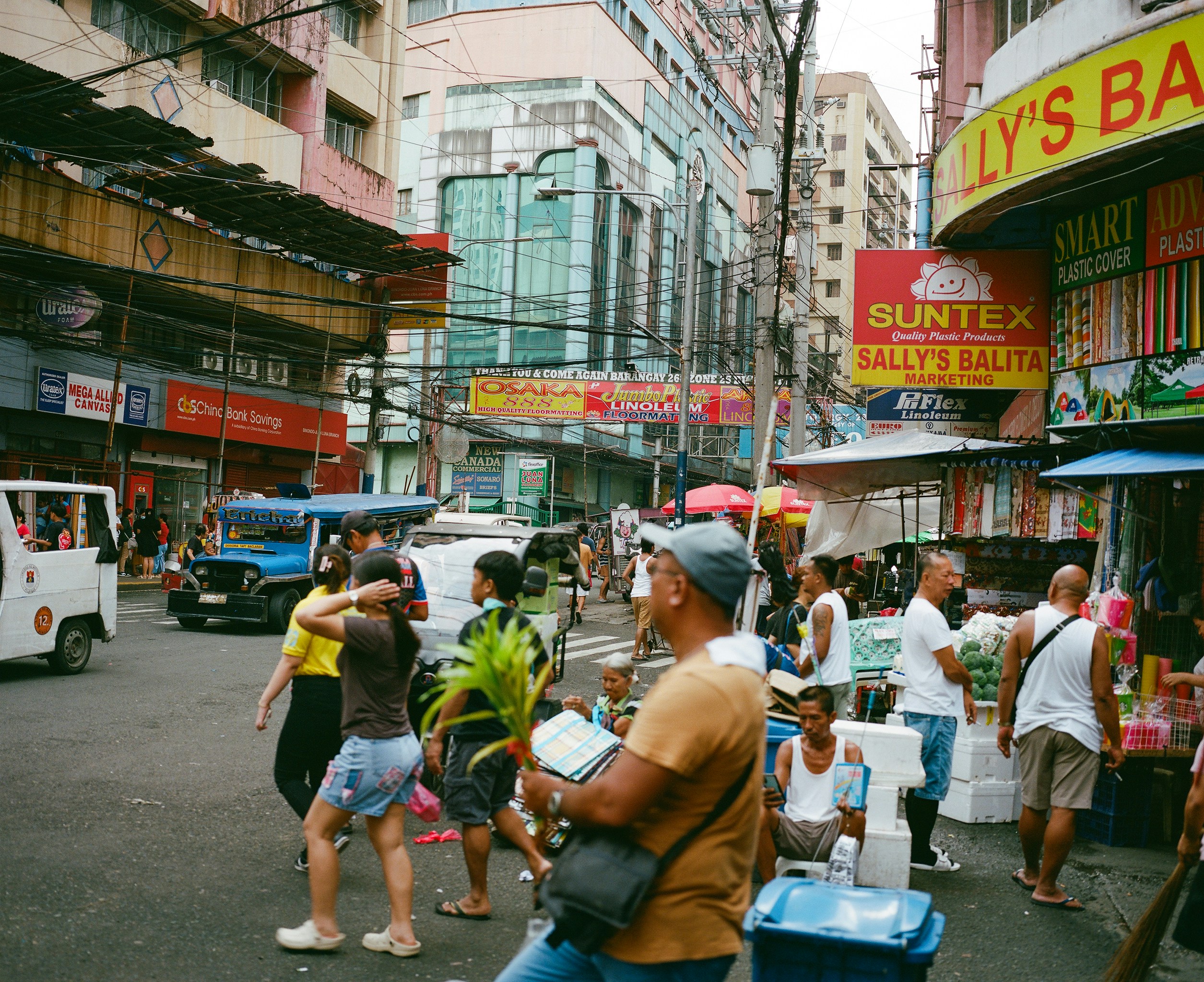 Bustling street market with people and vehicles.