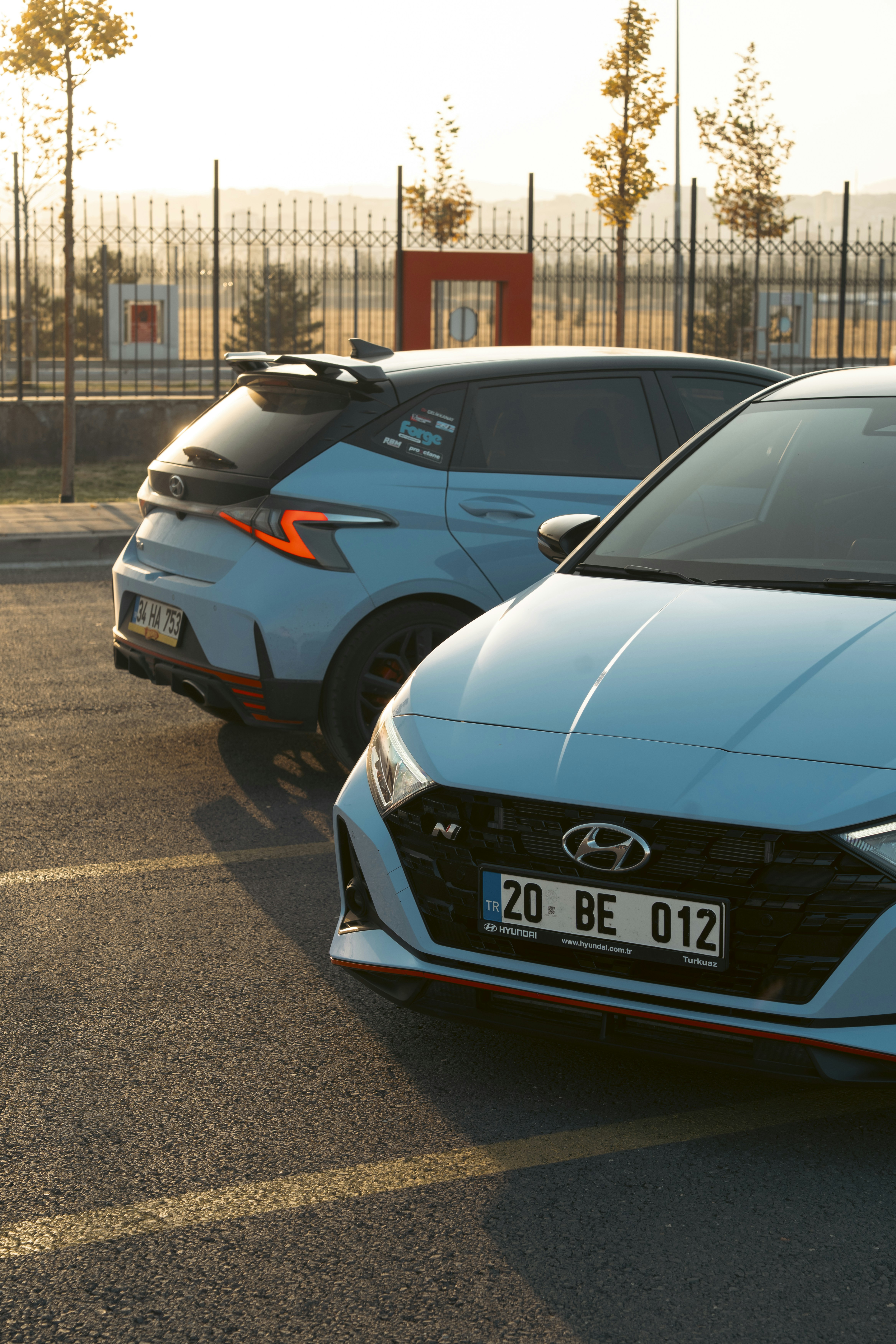 Two light blue performance cars parked side-by-side.