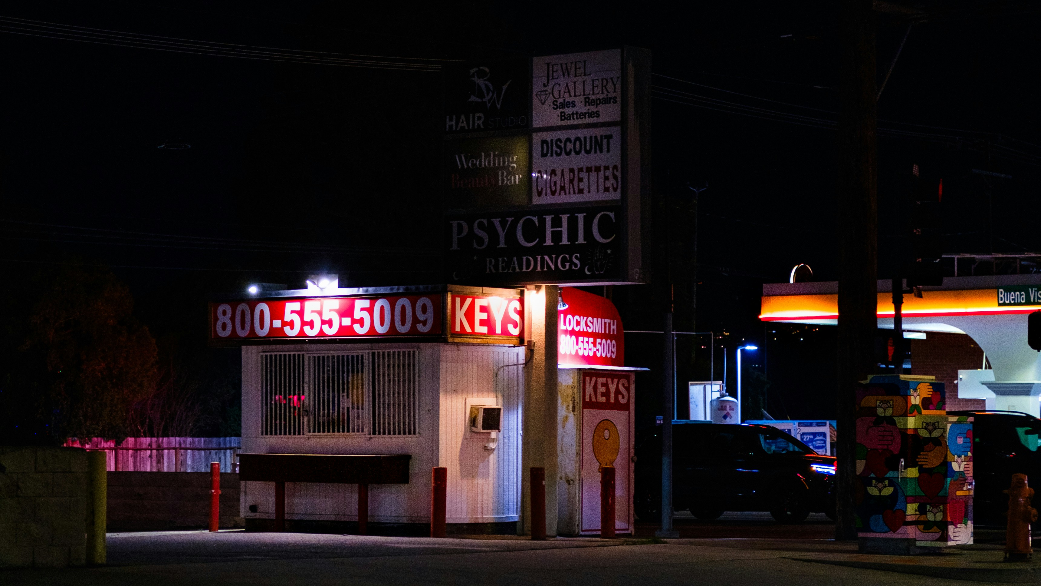 A psychic and key shop at night