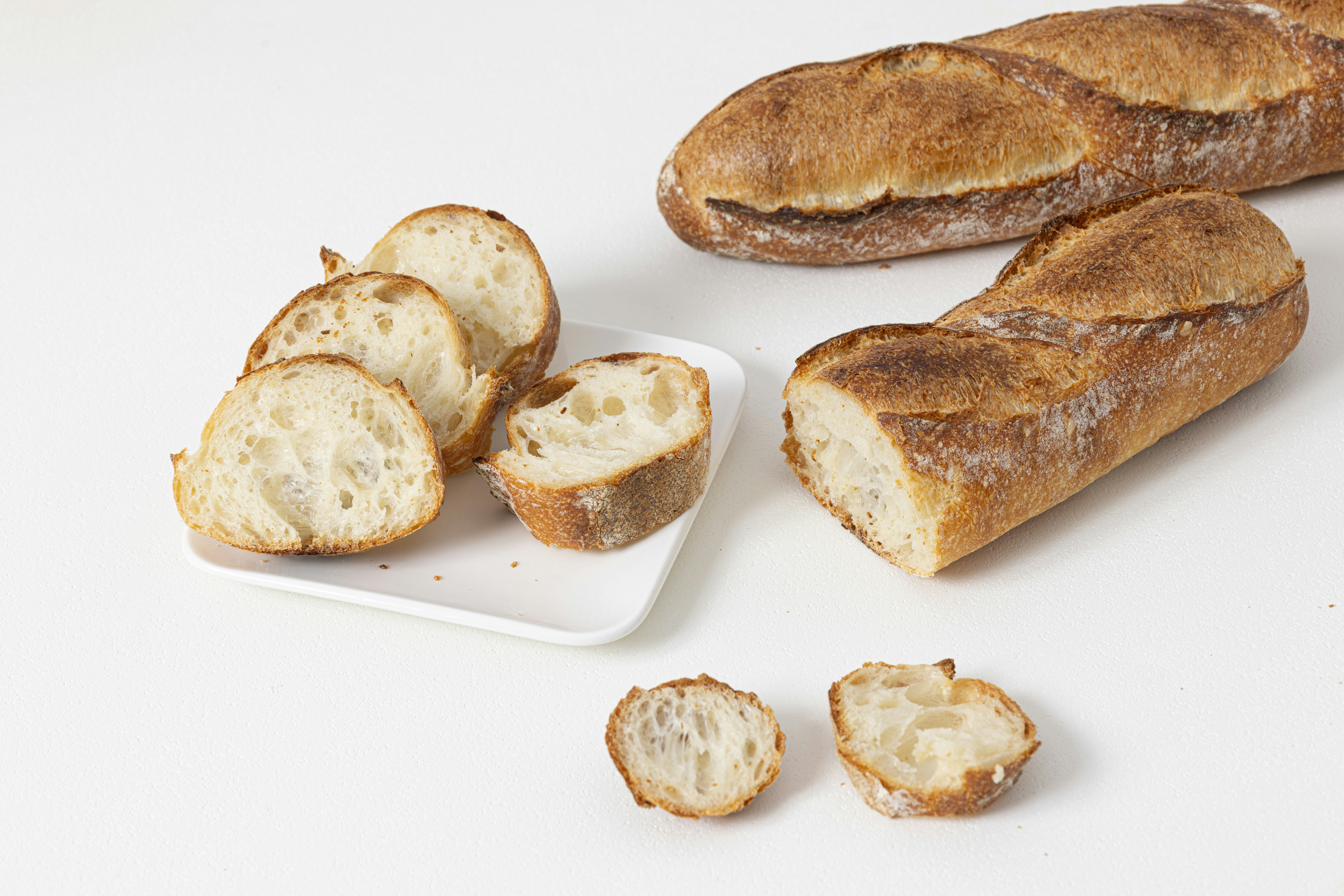 Deux baguettes, une tranchée, sur une surface blanche