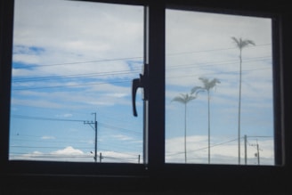 View of blue sky with clouds through a window