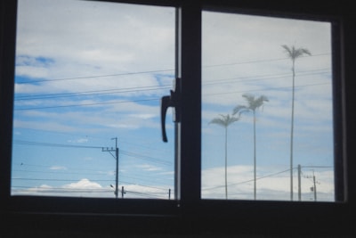 View of blue sky with clouds through a window